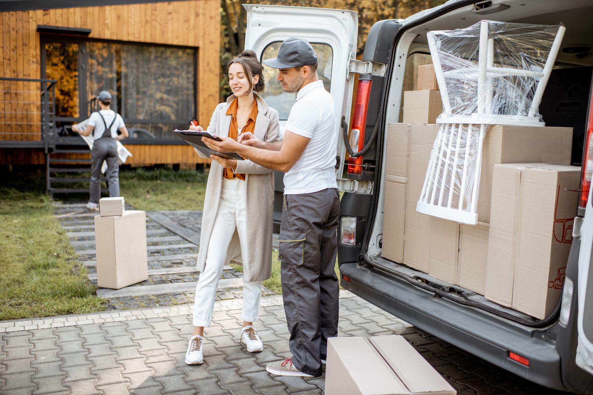Woman signing paperwork with delivery person at a home