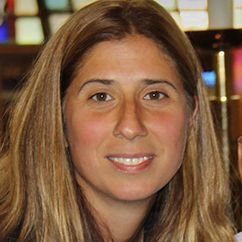 A woman with long blonde hair is smiling for the camera.