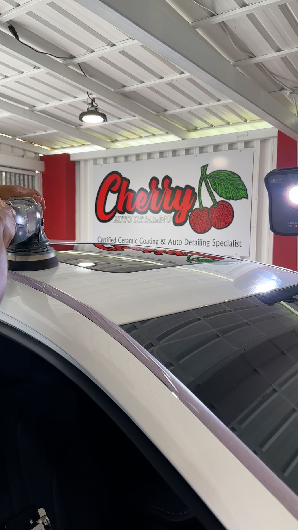 A car is parked in front of a cherry store.