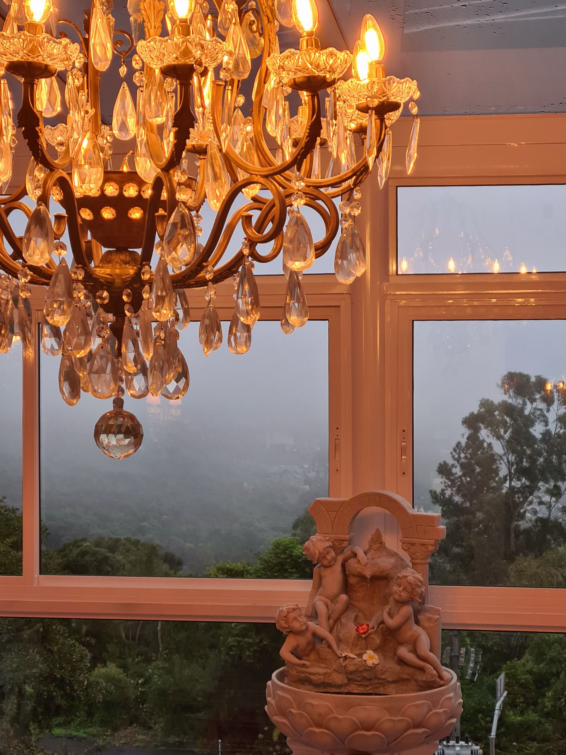 Um lustre está pendurado no teto acima de uma fonte