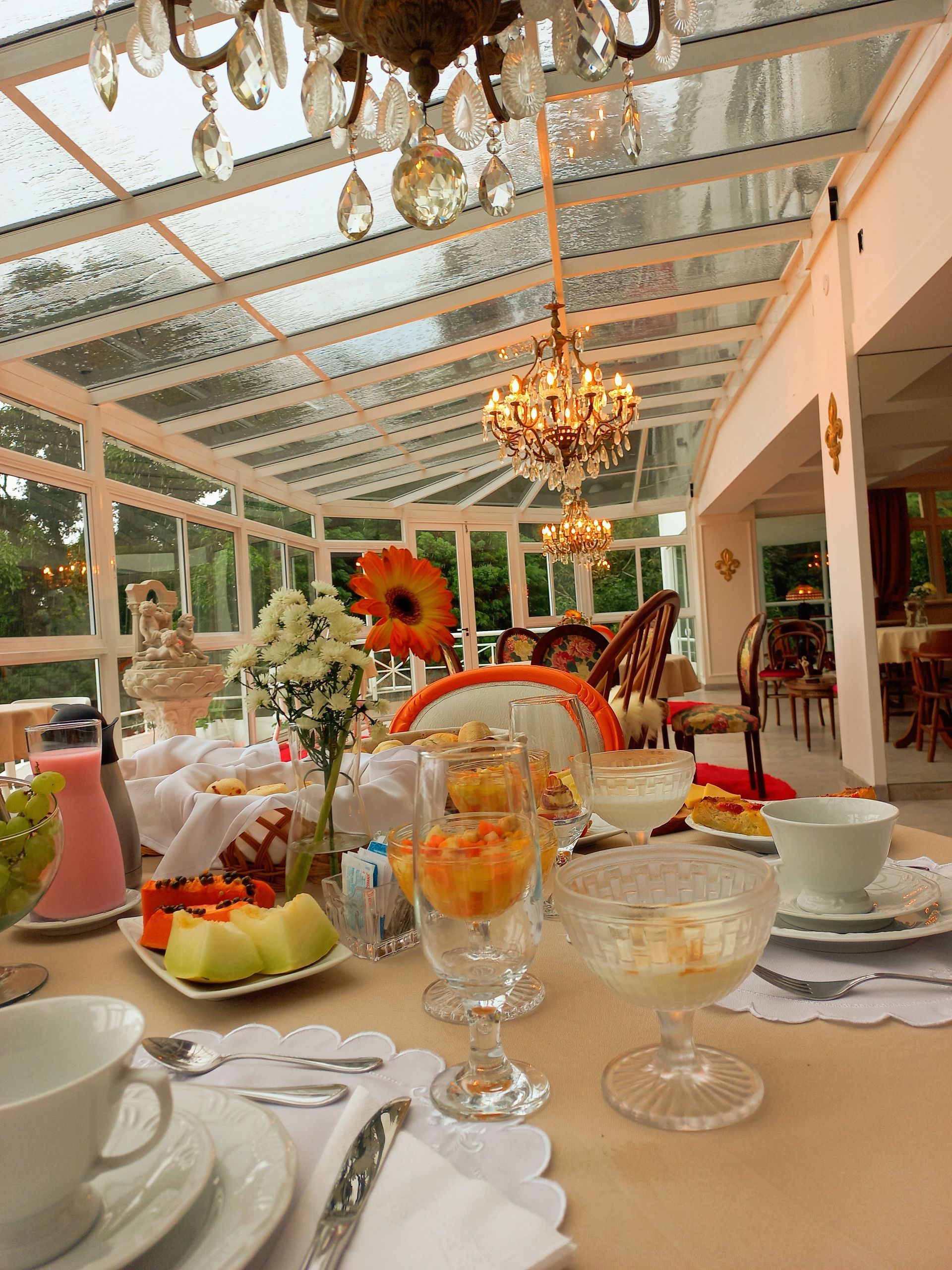 Uma mesa com pratos, xícaras, copos e frutas sobre ela