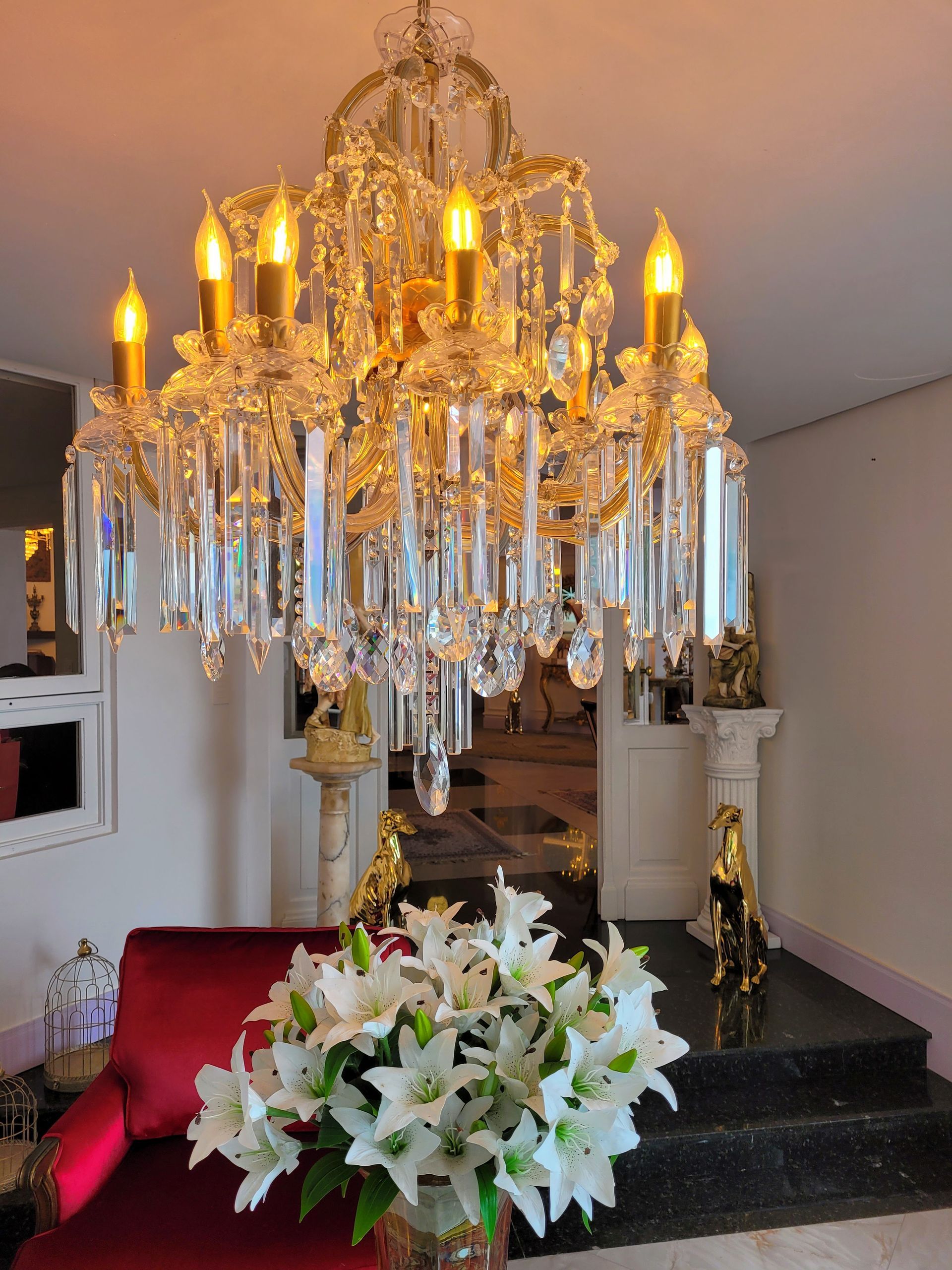 Uma sala de estar com um lustre e um vaso de flores