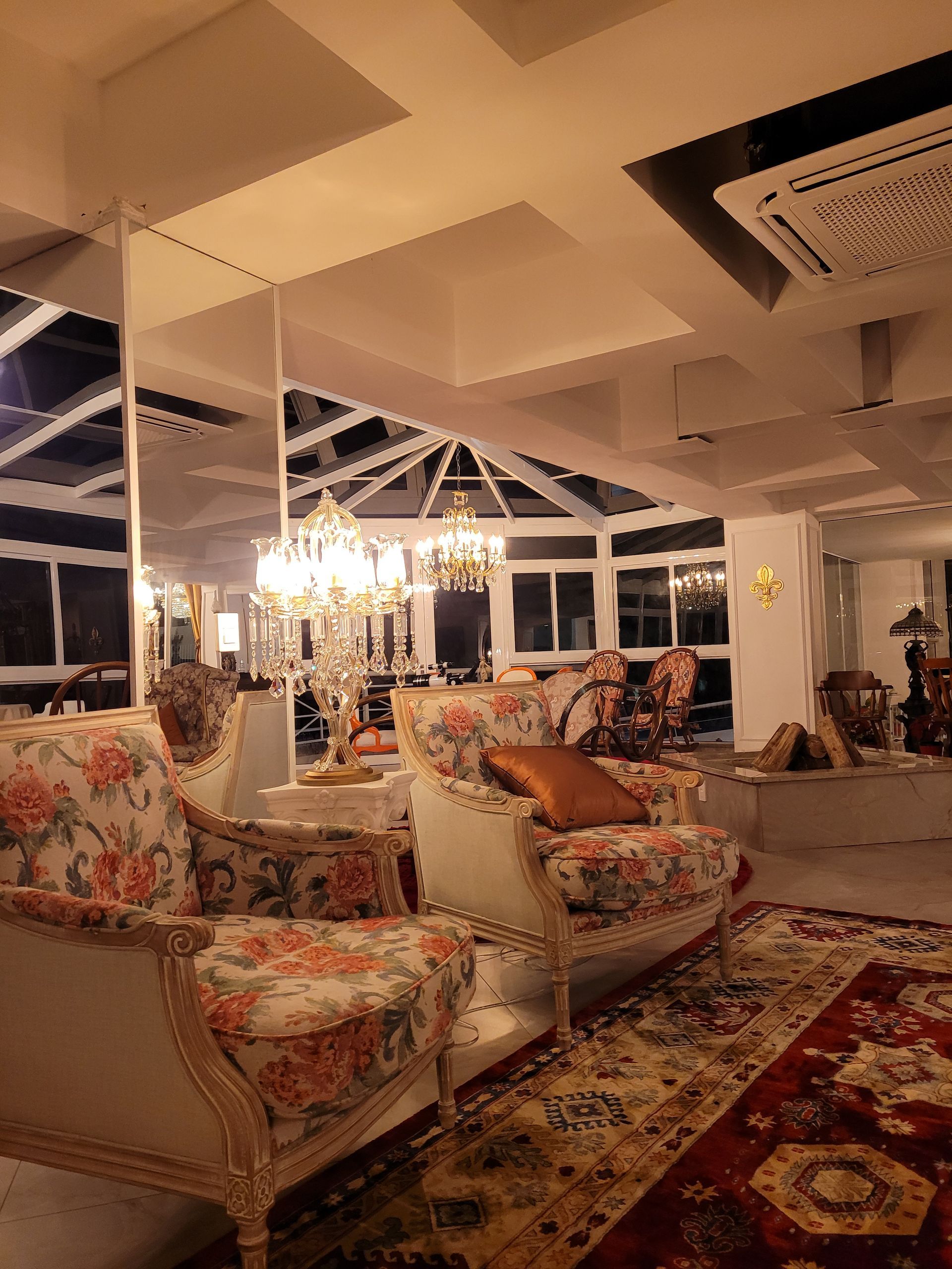 Uma sala de estar com um sofá, cadeiras e um tapete