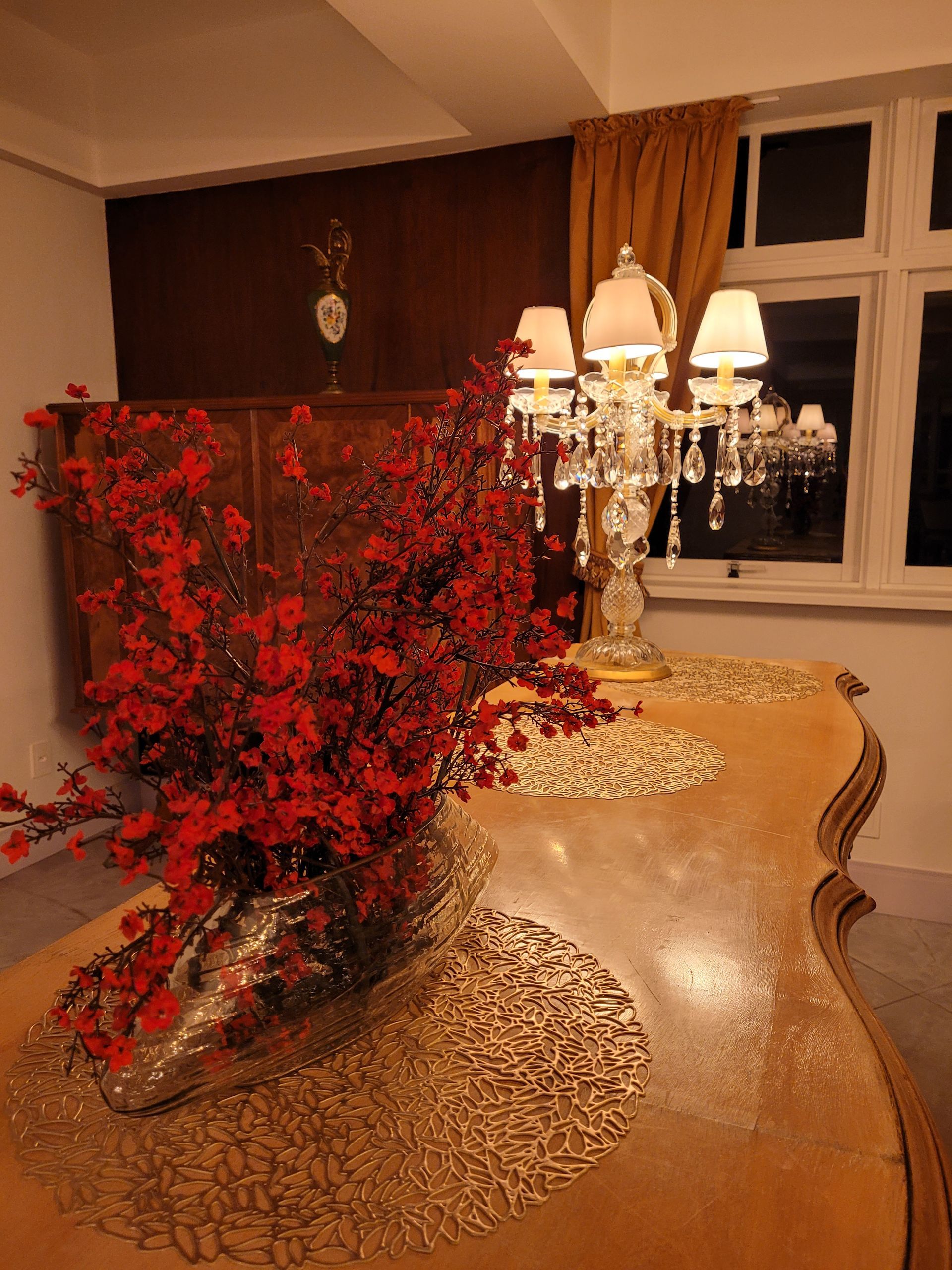 Uma mesa com um vaso de flores vermelhas sobre ela