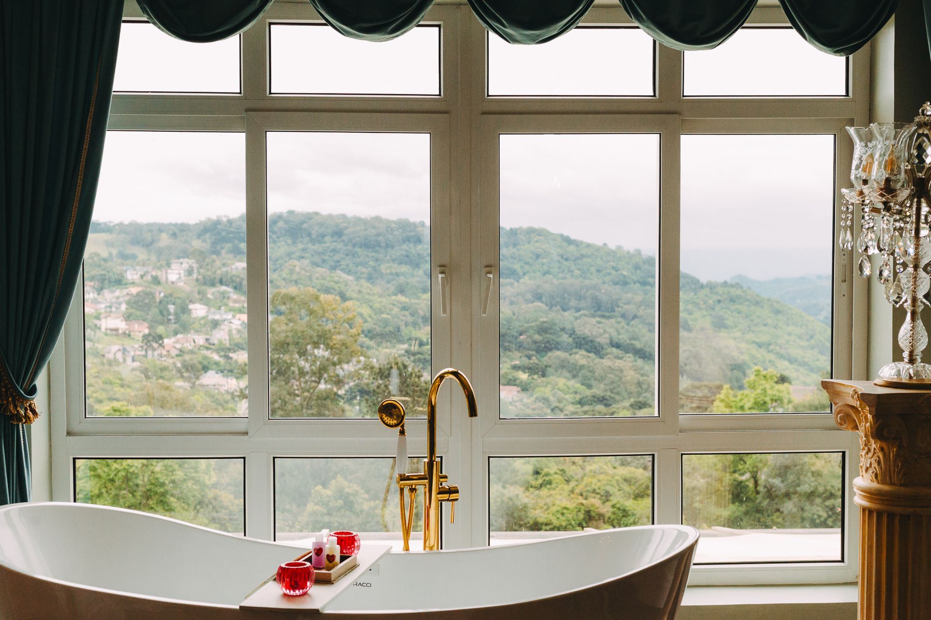 Uma banheira está em frente a uma janela com vista para uma montanha.