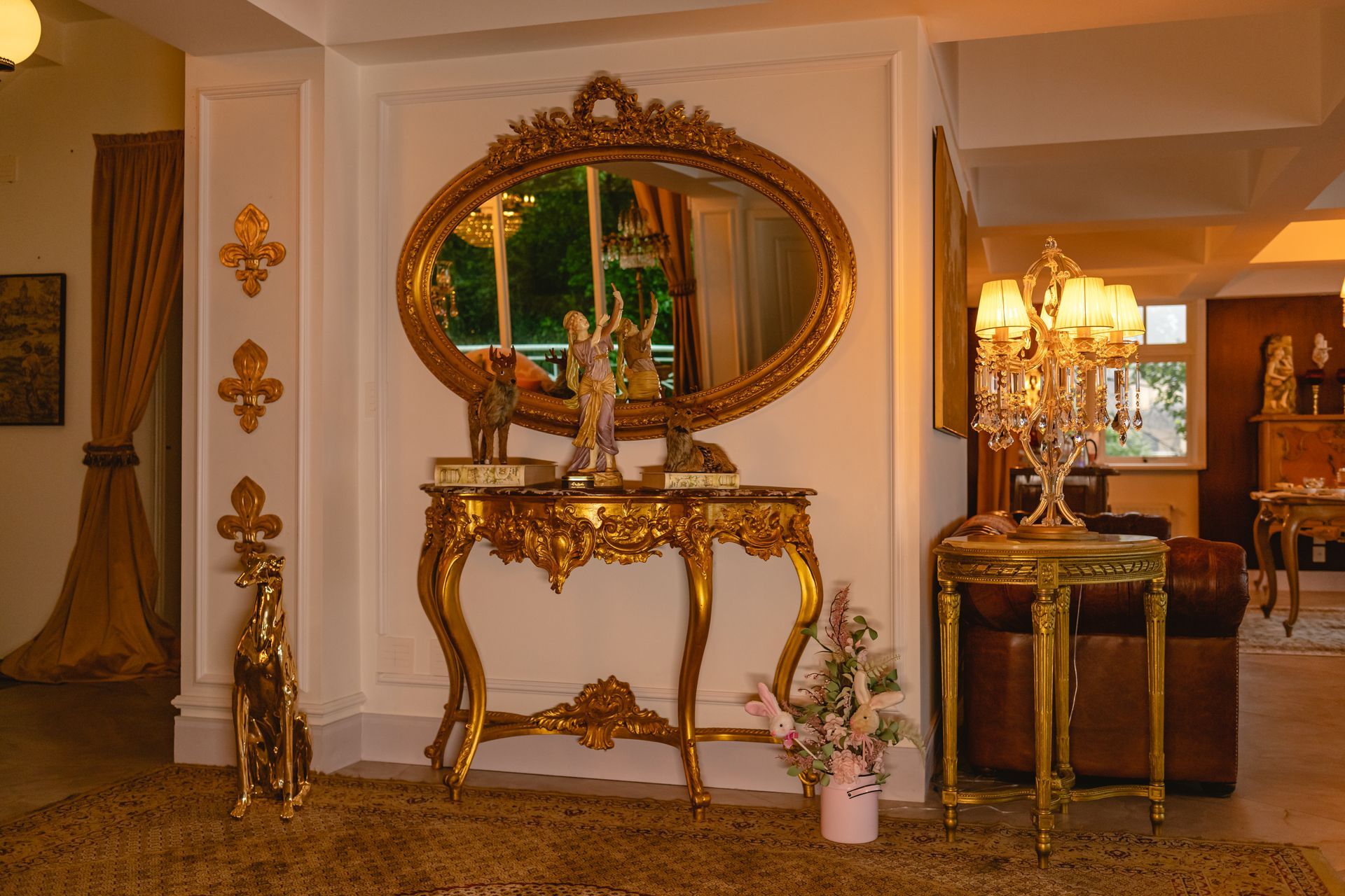 Uma sala de estar com mesa, espelho, luminárias e um sofá.