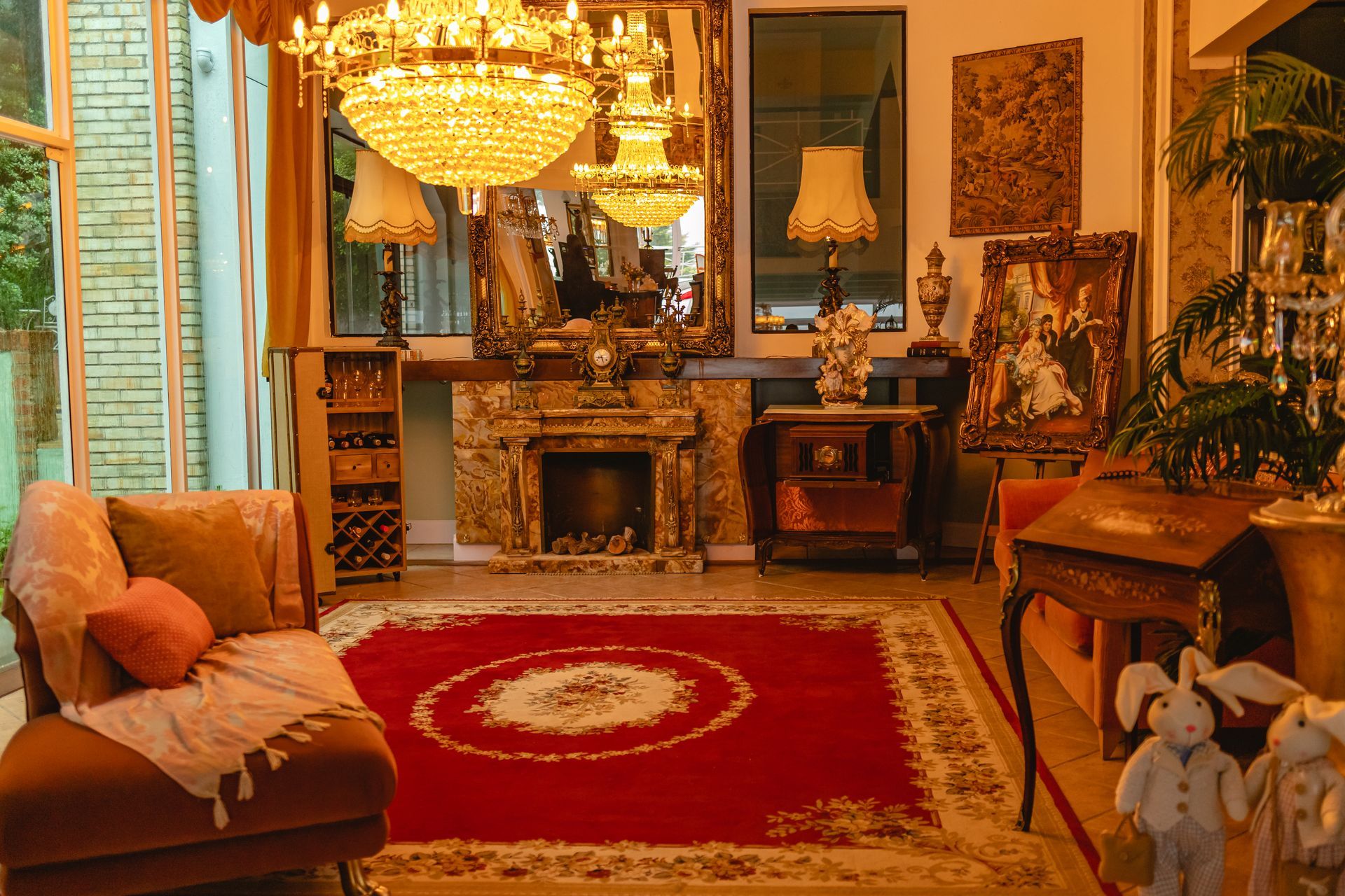 Uma sala de estar com um tapete vermelho, um sofá, uma lareira e um lustre.