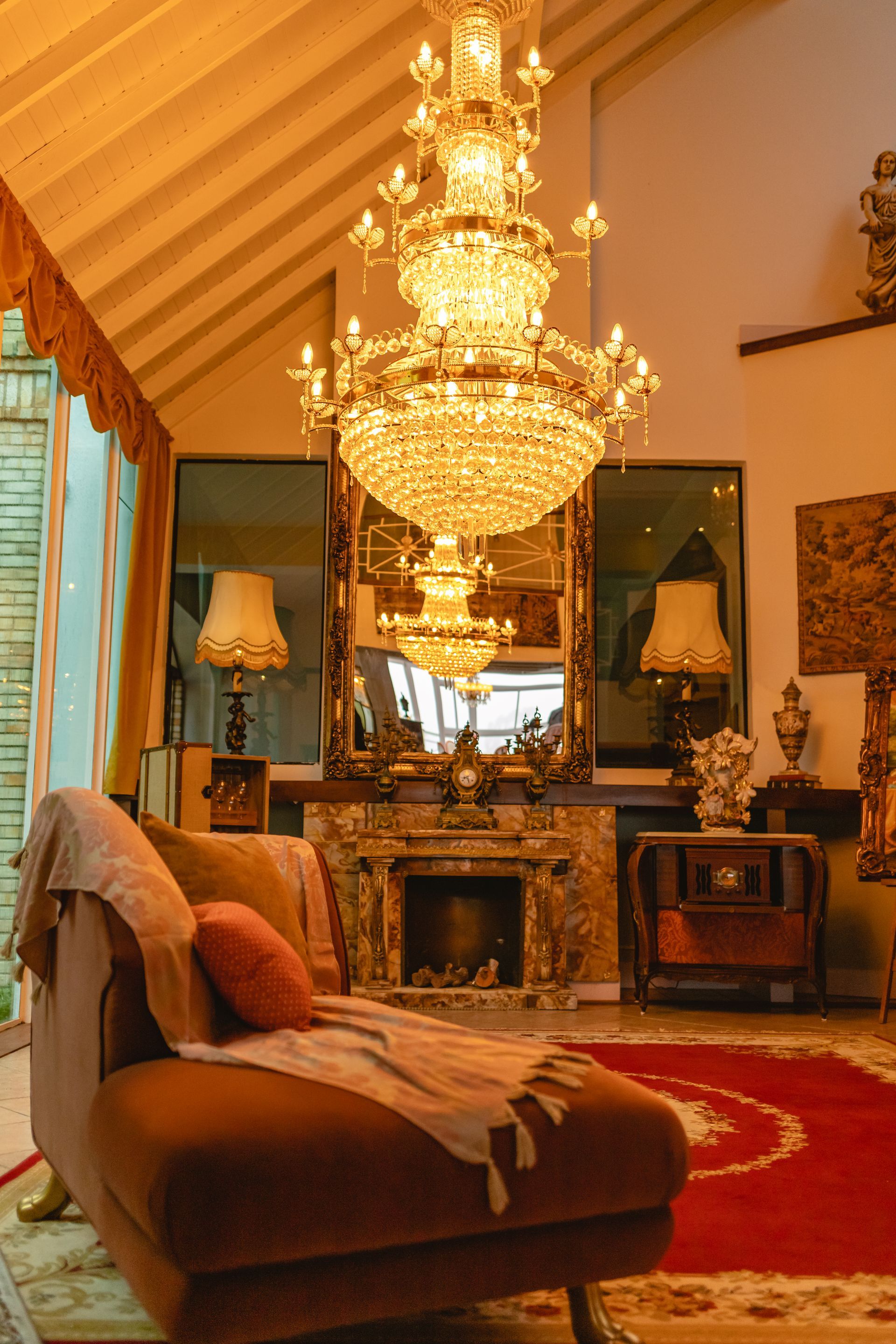 Uma sala de estar com sofá, lareira e lustre.