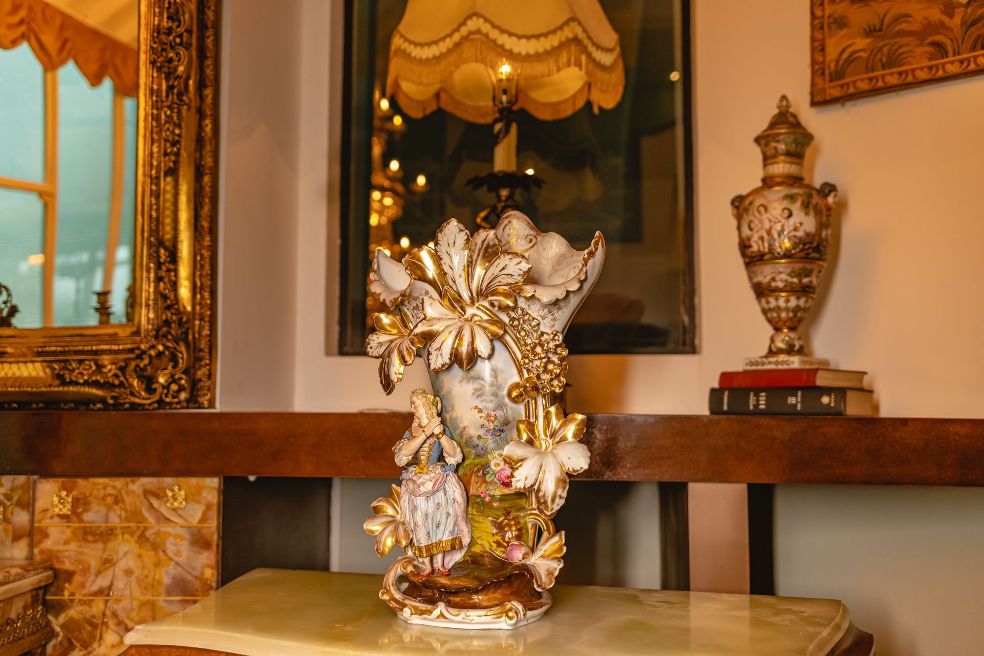 Um vaso com flores está sobre uma mesa ao lado de um abajur.