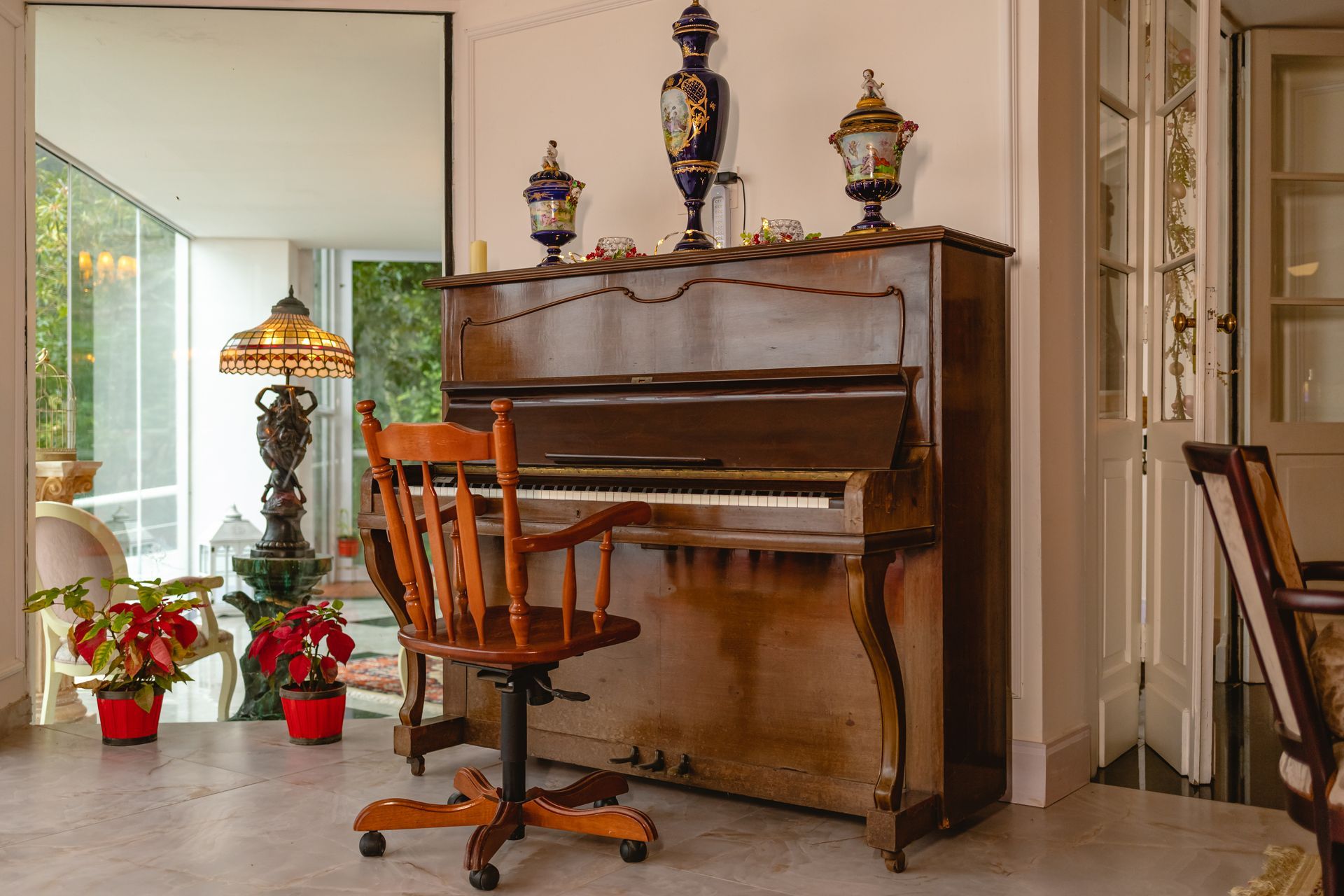 Um piano está em uma sala de estar ao lado de uma cadeira.