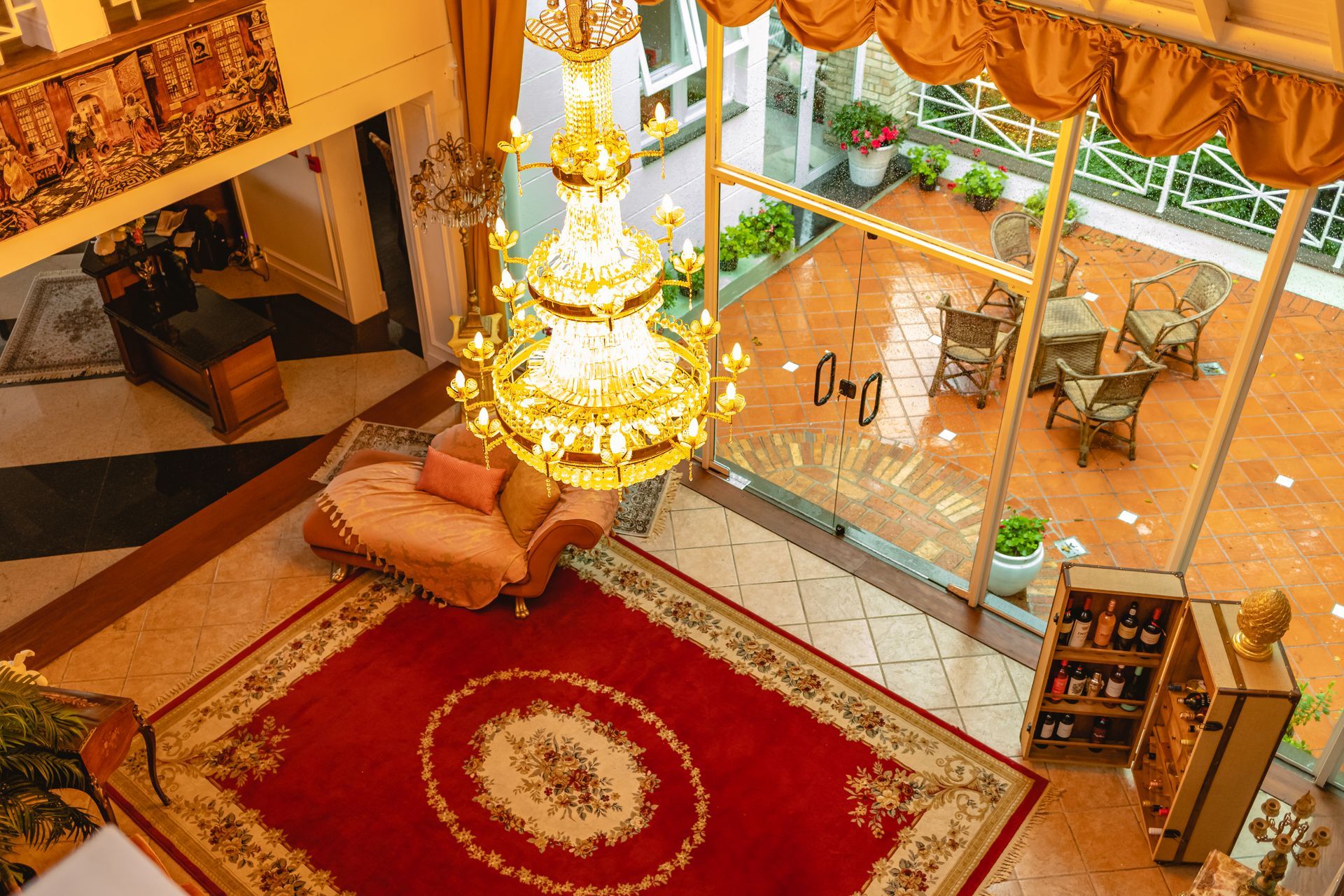 Uma vista aérea de uma sala de estar com um tapete vermelho e um lustre