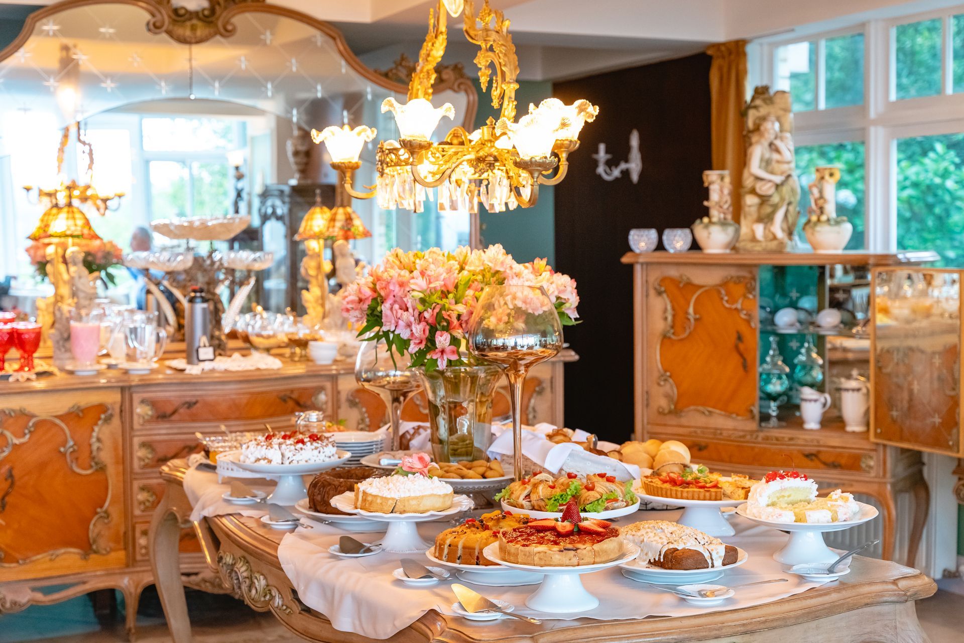 Uma mesa coberta com uma variedade de sobremesas e flores.