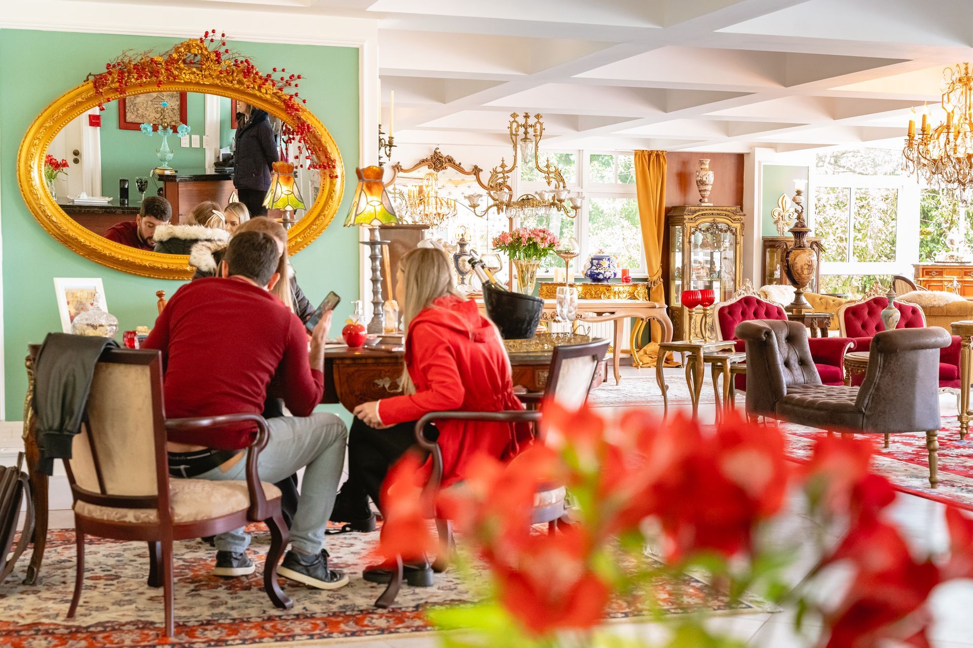Um grupo de pessoas está sentado em mesas em uma sala de estar.