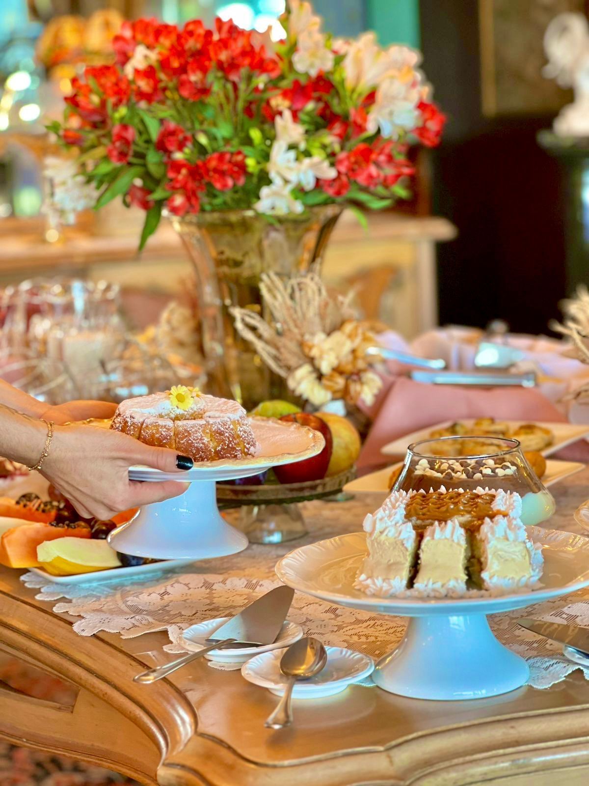 Uma mesa coberta com pratos de comida e um vaso de flores.