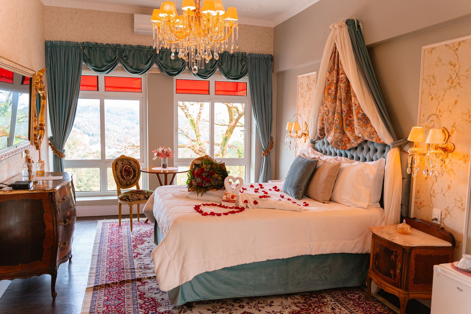 Um quarto com uma cama king size e um lustre.