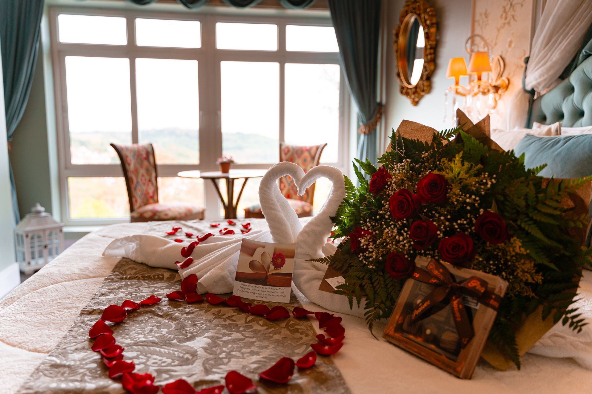 Uma cama com um buquê de flores e toalhas em forma de cisnes.