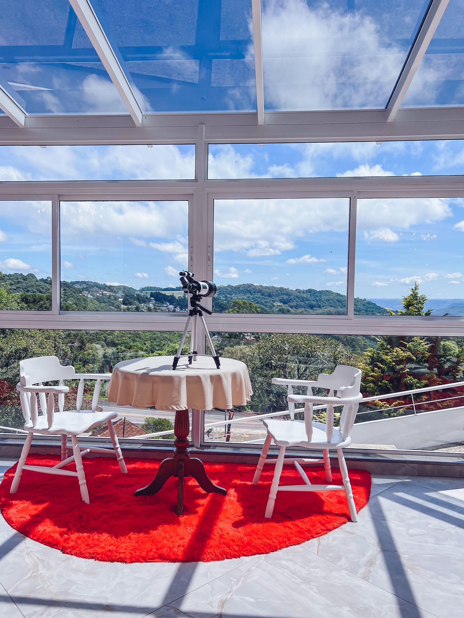 Uma mesa e cadeiras em uma varanda com vista para as montanhas
