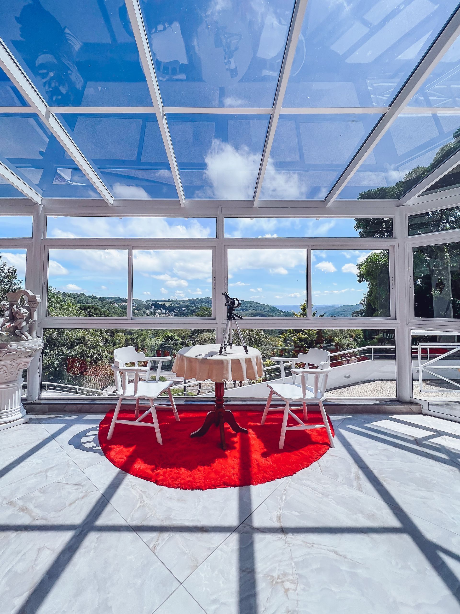 Uma mesa e cadeiras em uma sala com teto de vidro.