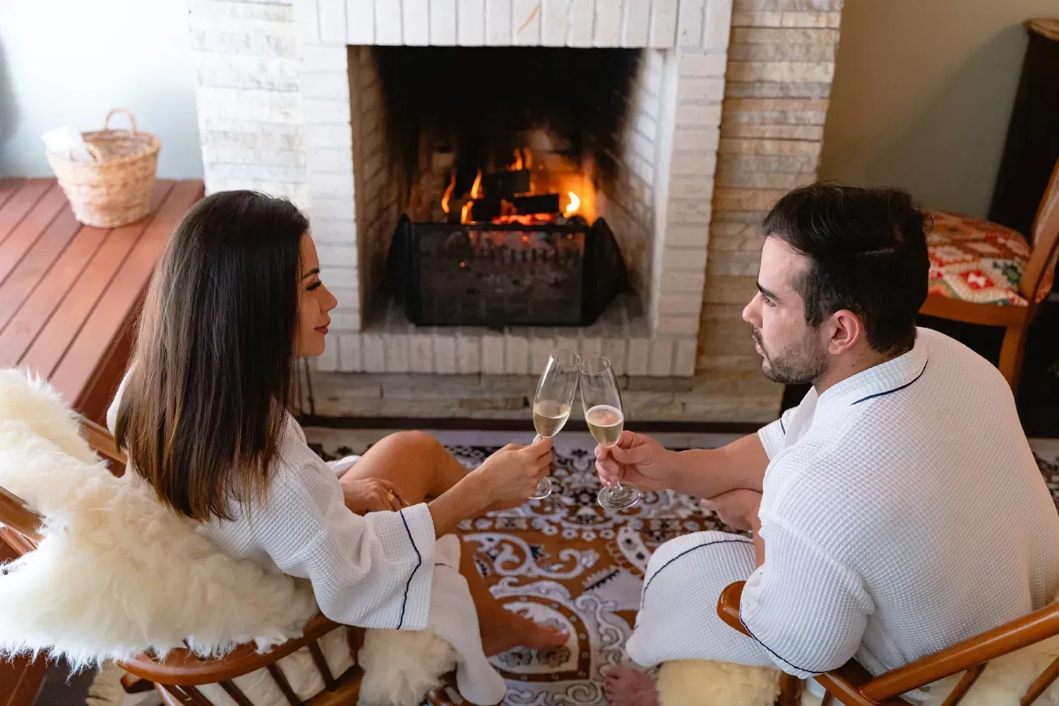 Um homem e uma mulher estão sentados em cadeiras de balanço em uma sala de estar.