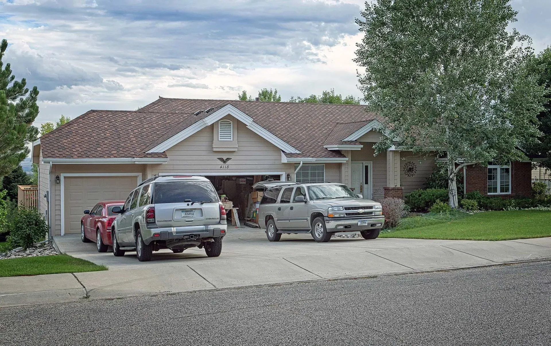A couple of cars are parked in front of a house