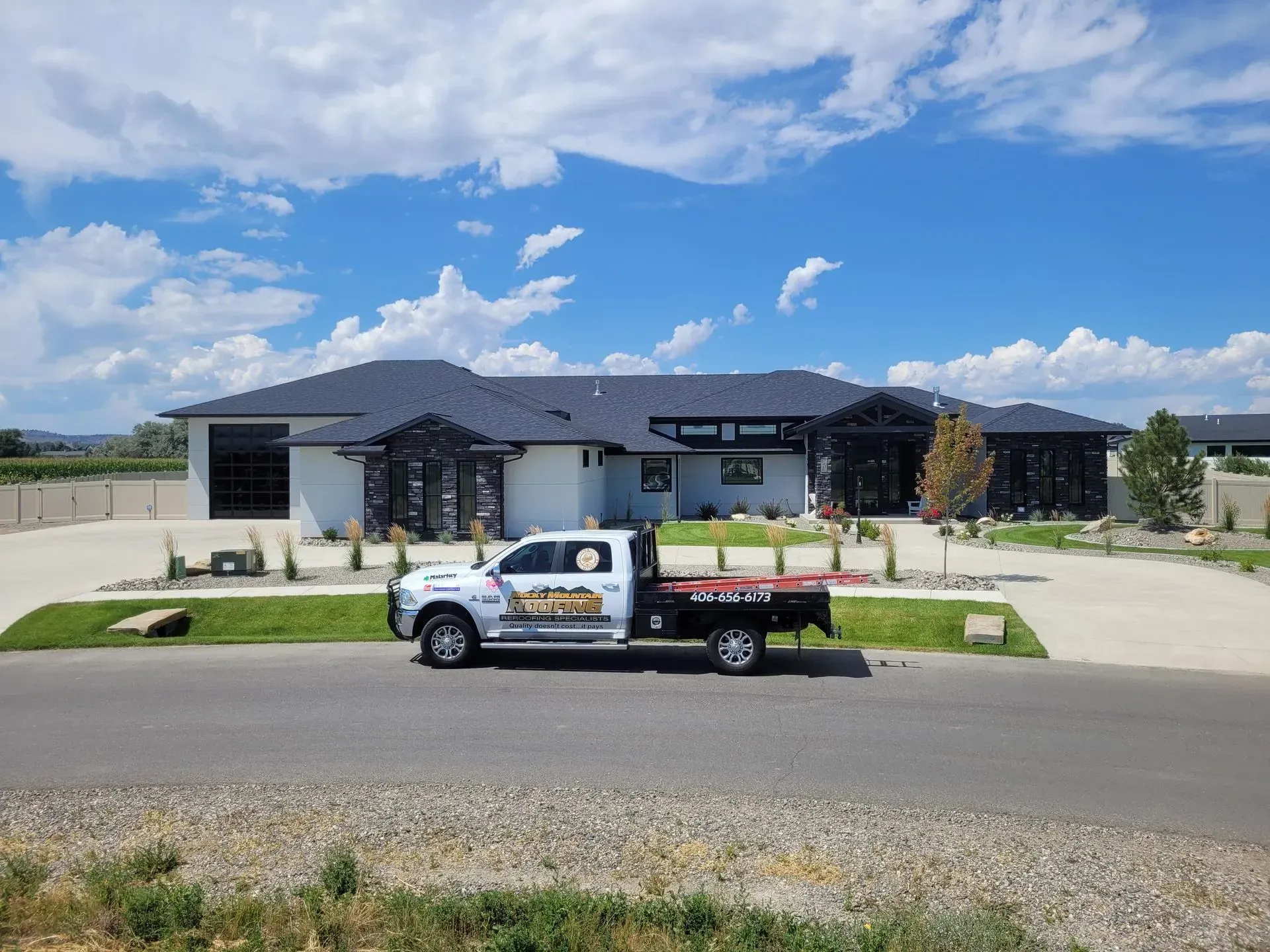 A white truck is parked in front of a large house.