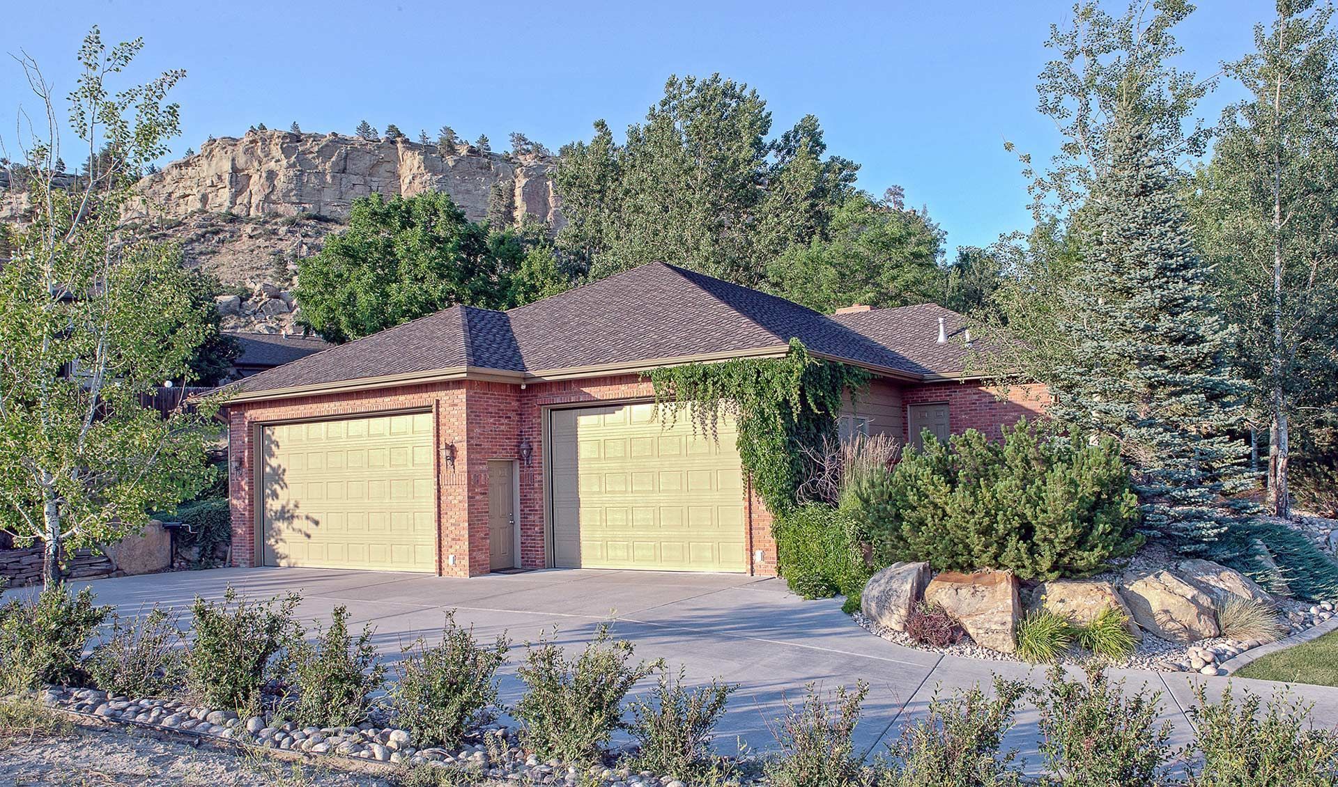 A house with two garage doors and a mountain in the background