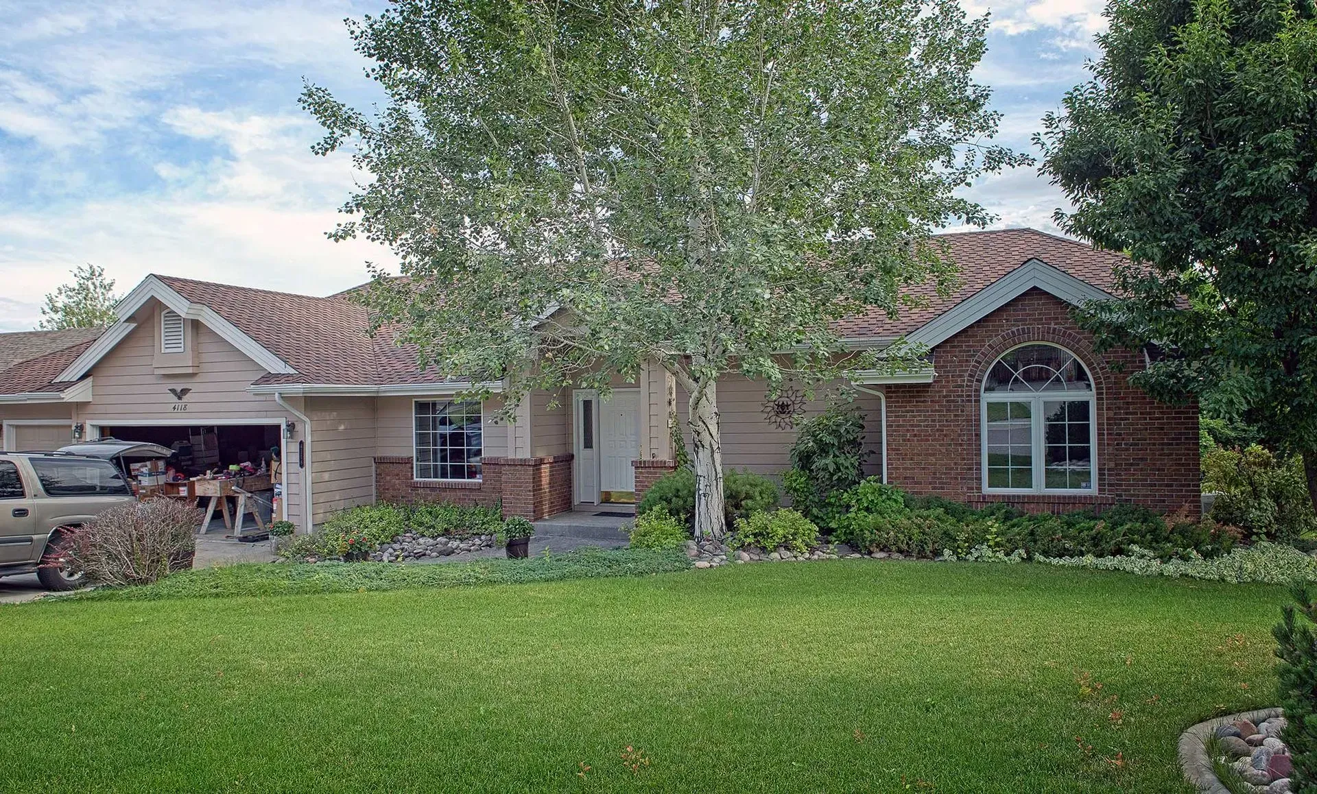 A brick house with a car parked in front of it