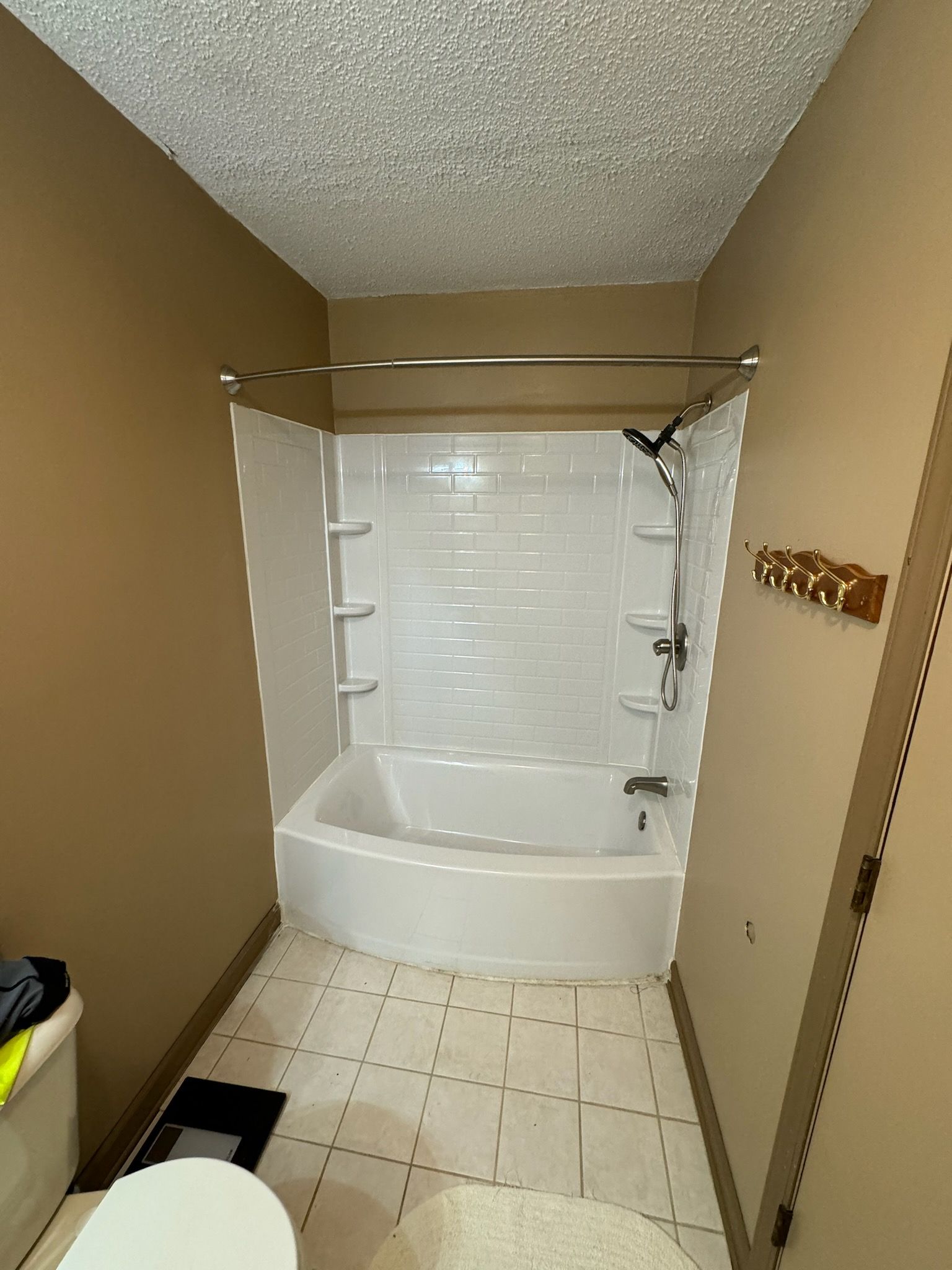 A bathroom with a tub , toilet and shower.