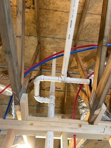 A bunch of pipes are hanging from the ceiling of a building.