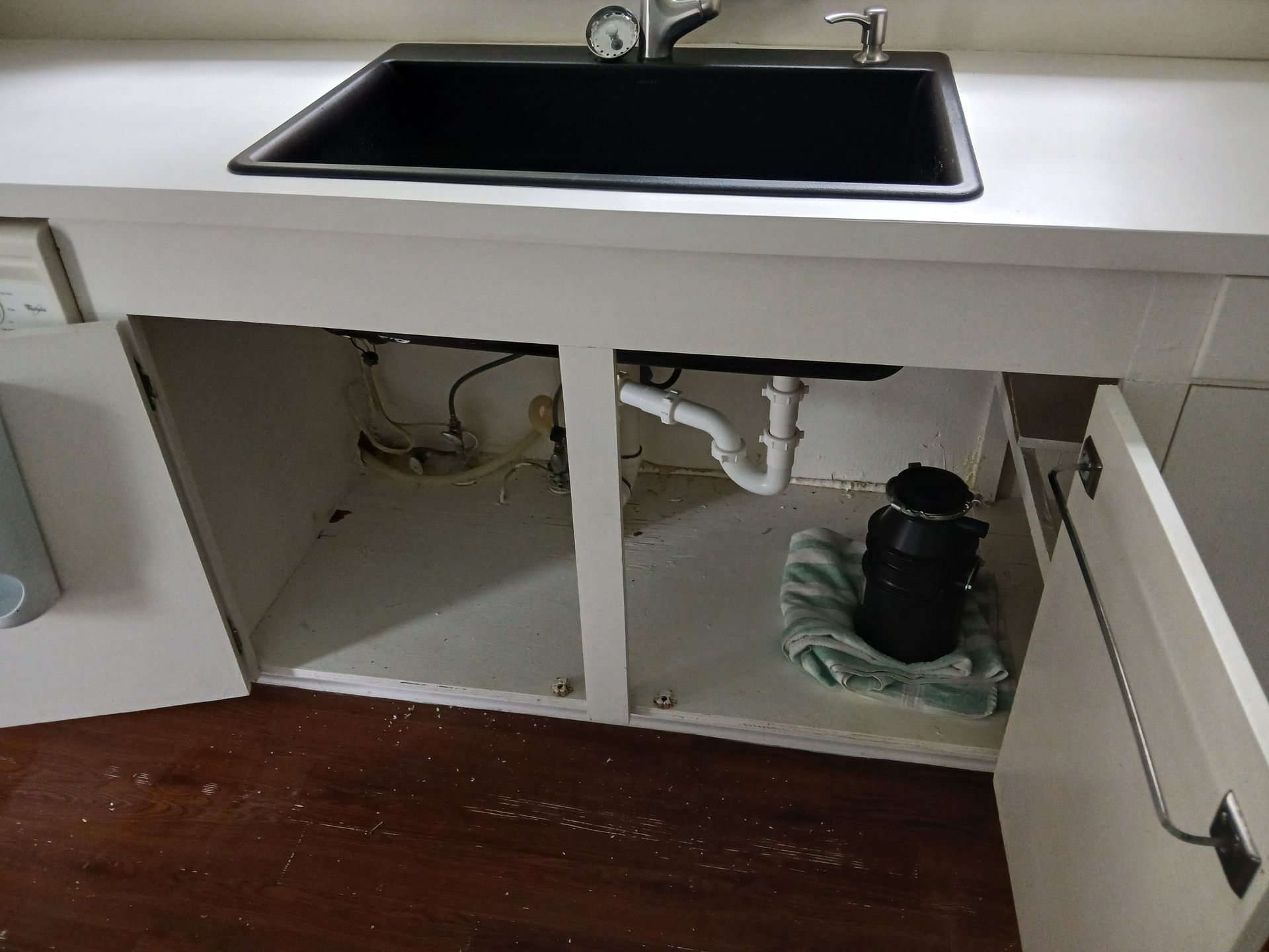 A kitchen sink with a garbage disposal underneath it.