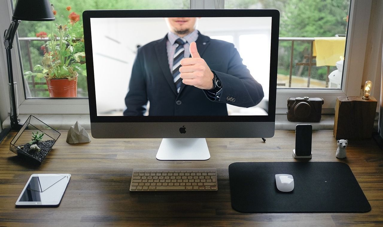 A computer video screen with a man in a suit and tie.