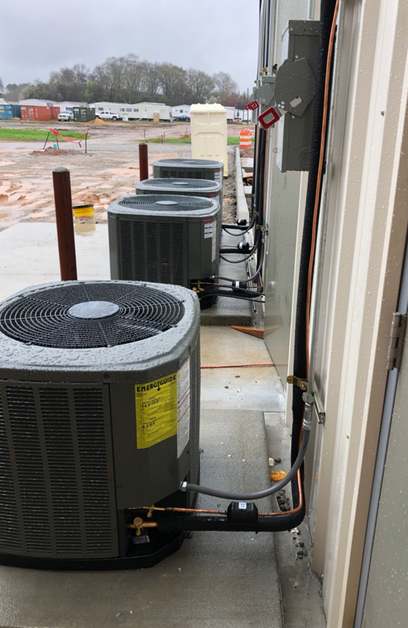 a row of air conditioners on the side of a building