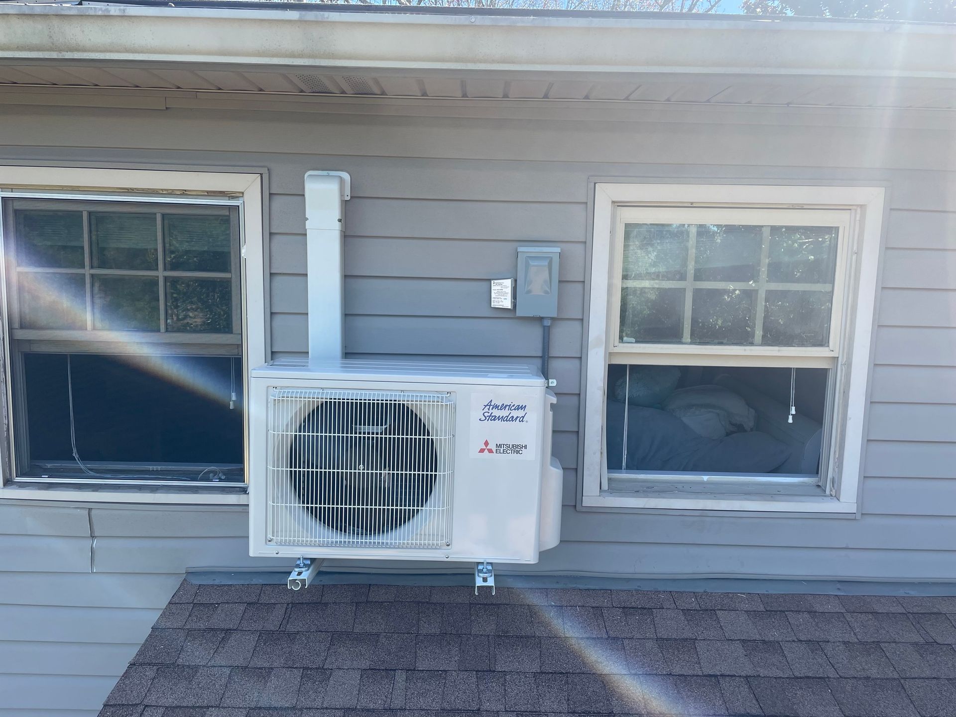 an air conditioner is mounted on the side of a house