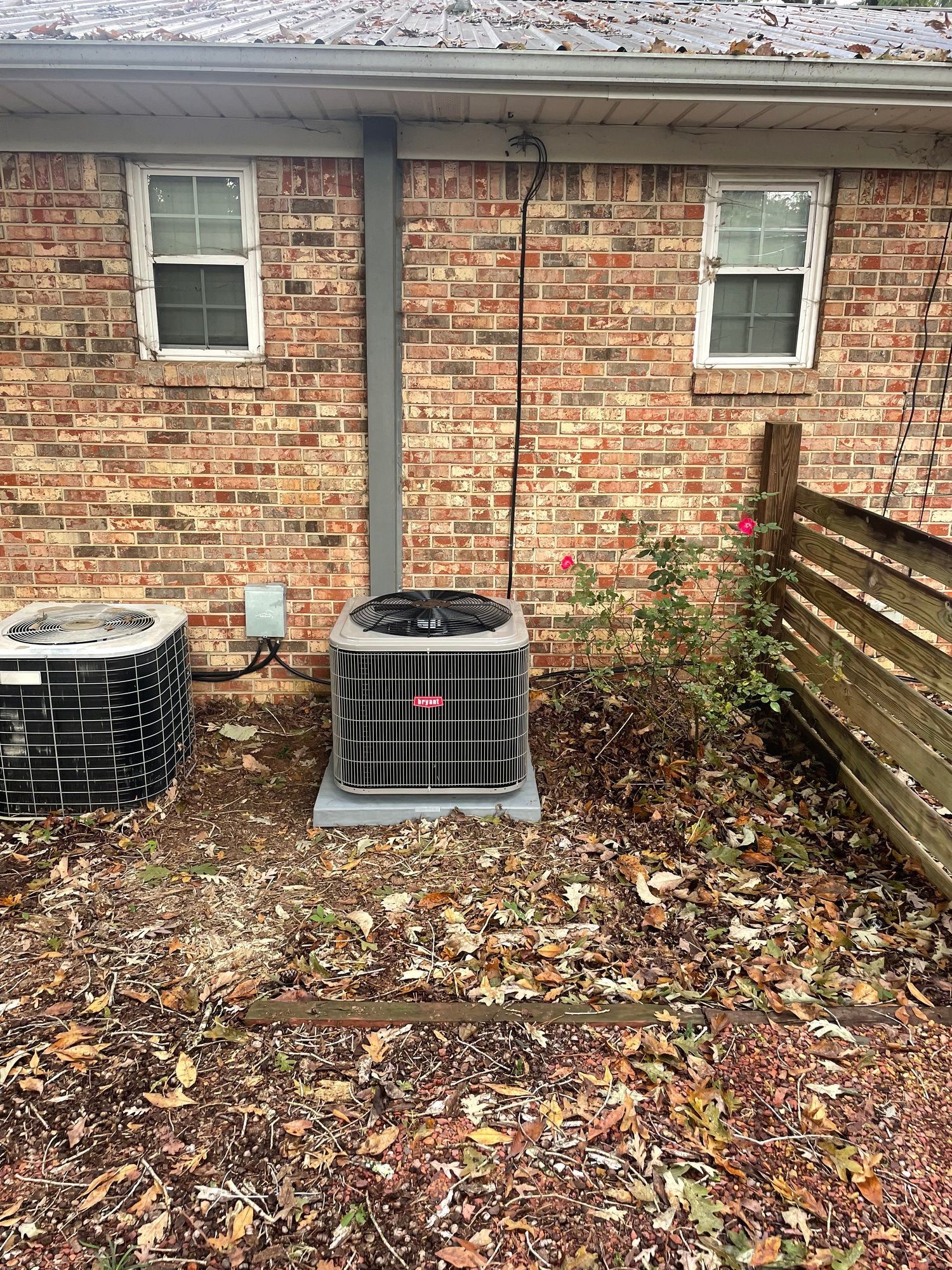 a brick house with a air conditioner in the backyard .