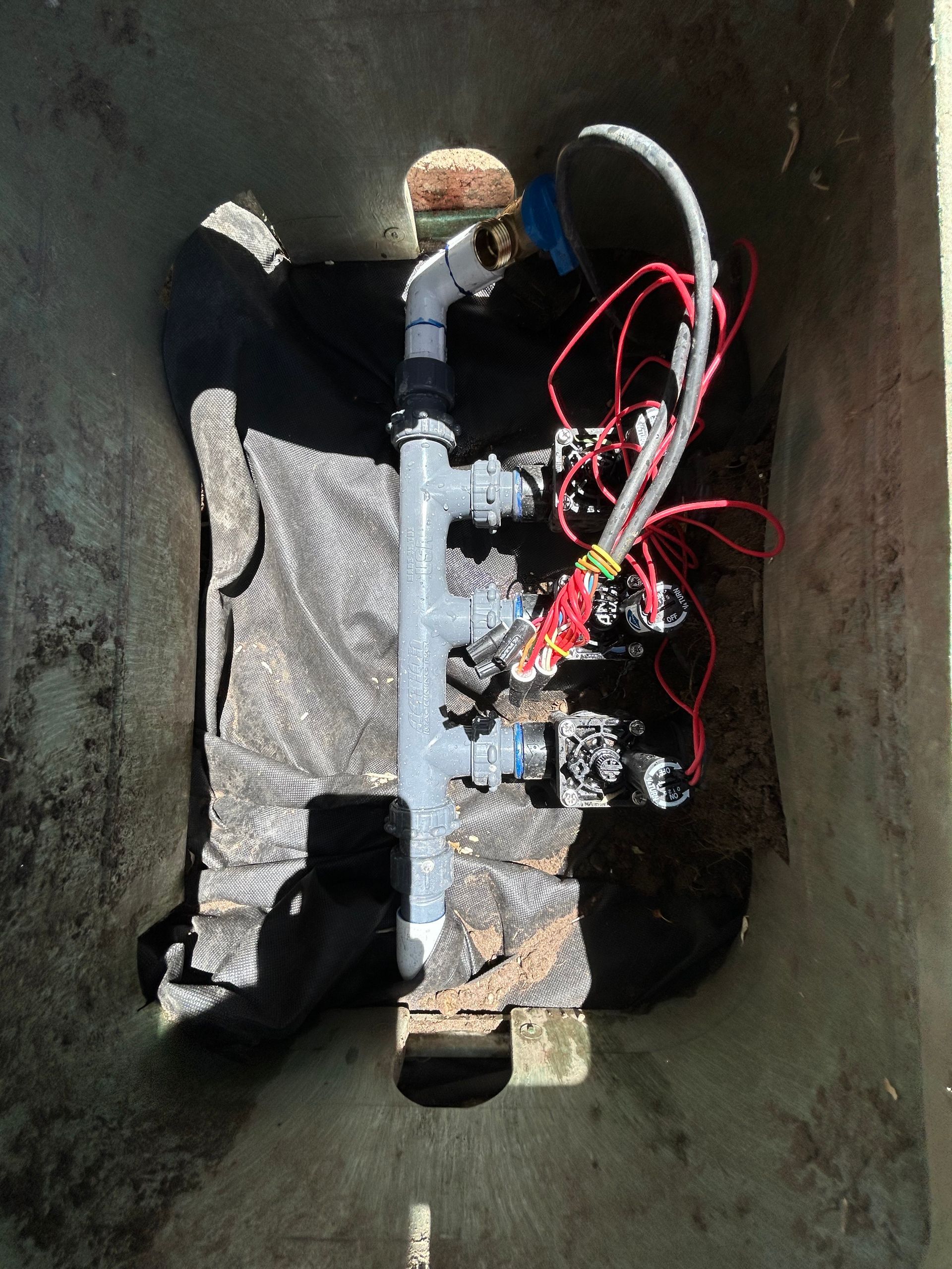 A pipe is laying in the dirt in a hole.