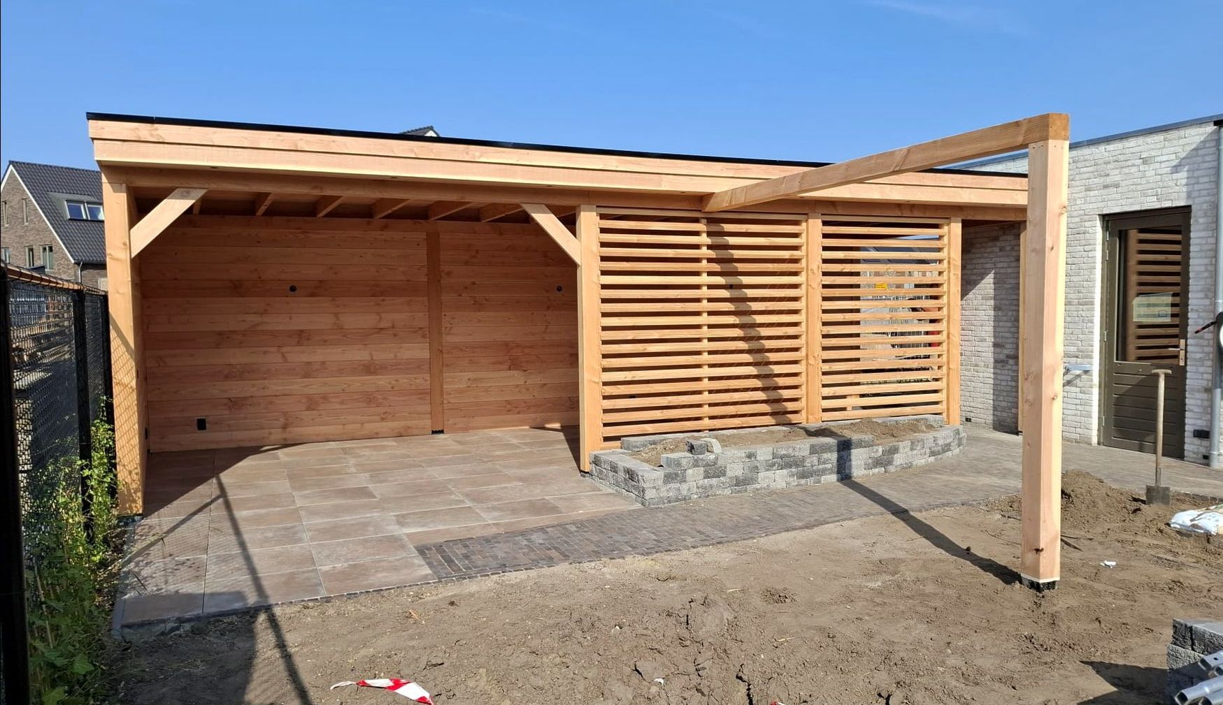 Er wordt een houten constructie gebouwd in de achtertuin van een huis.