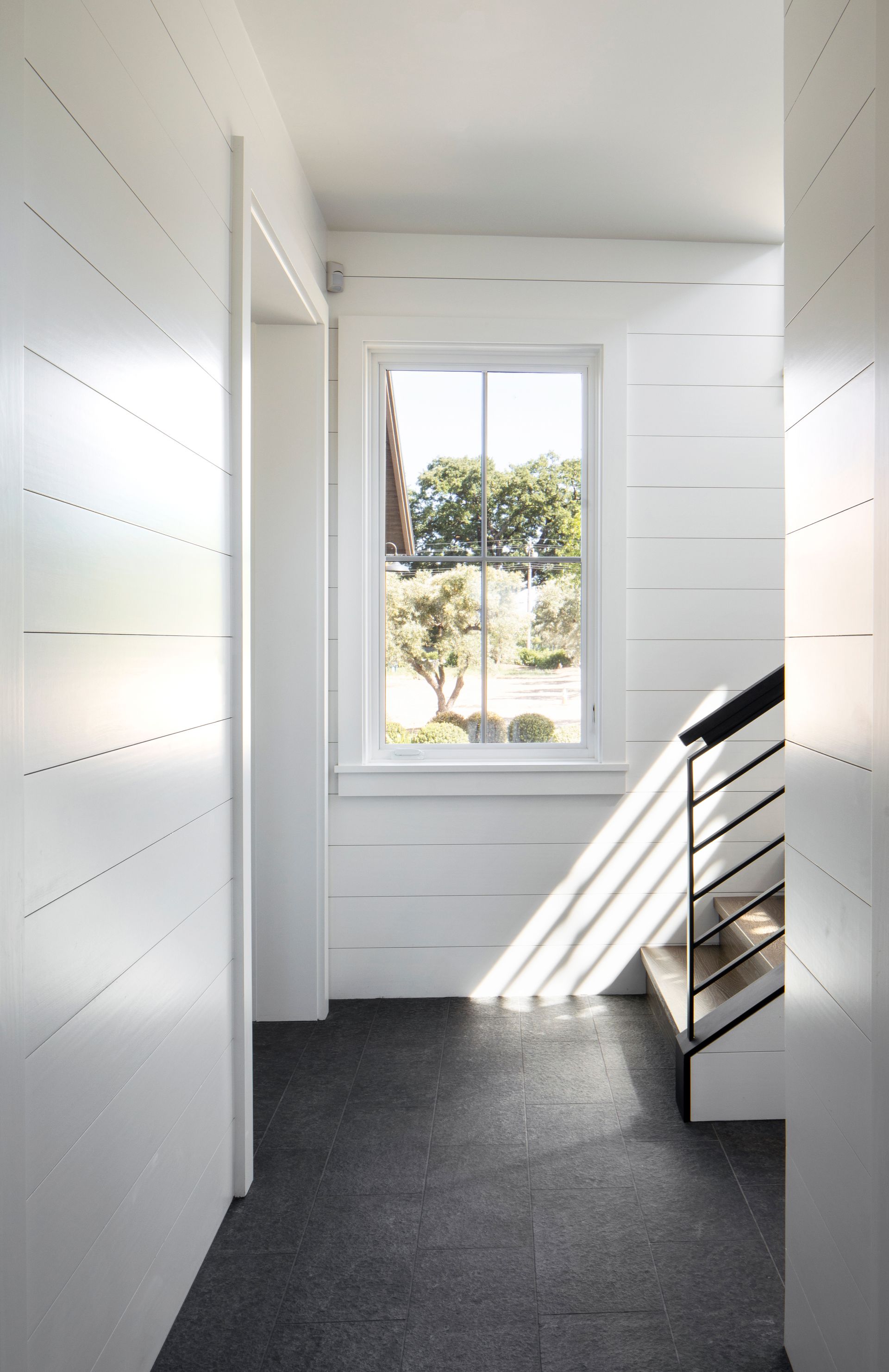 White hallway with dark gray floor, built by Nunley Custom Homes in Greenville, SC.
