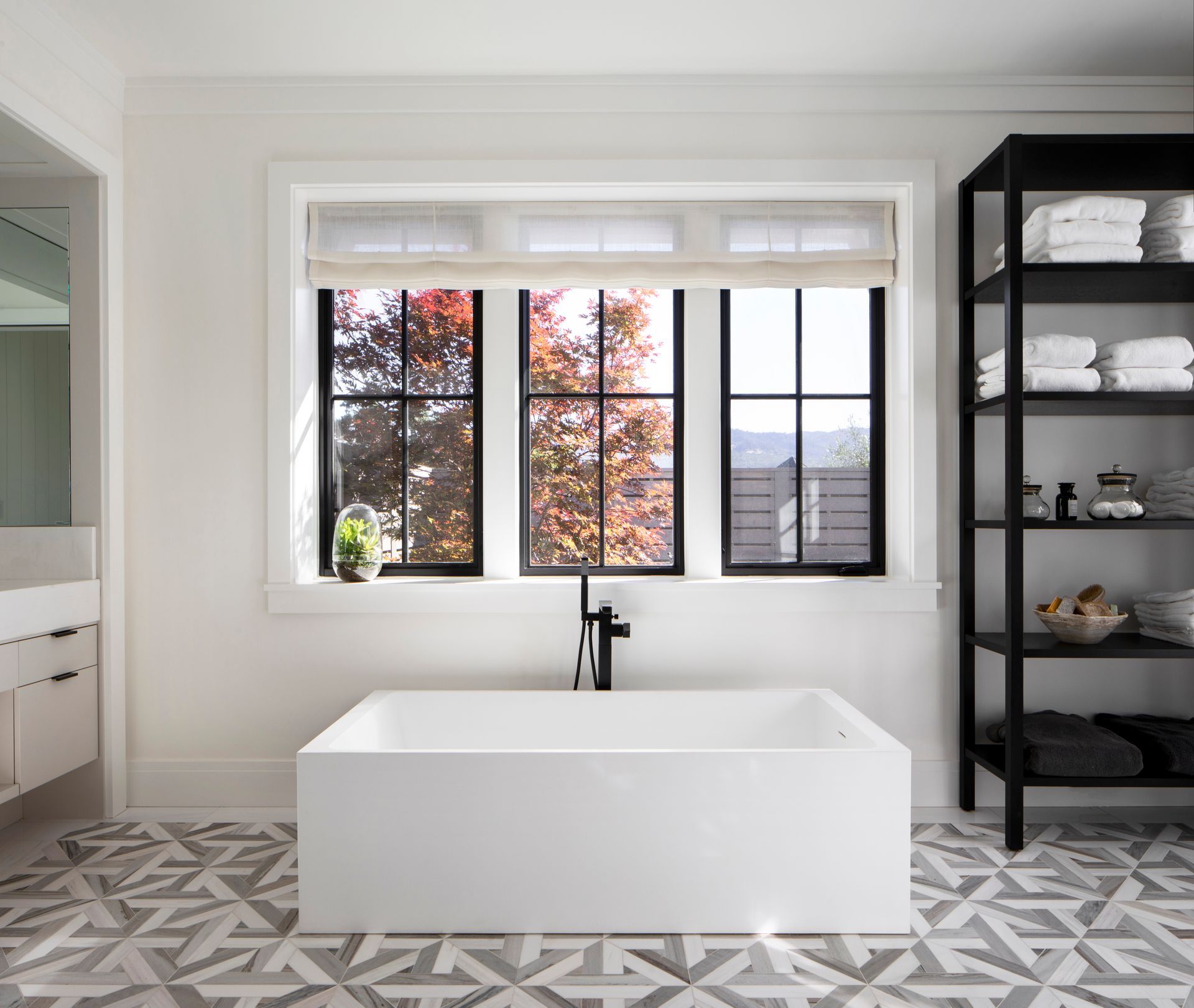 Modern bathroom with a white soaking tub, patterned floor remodeled by Nunley Custom Homes in Greenville, SC.