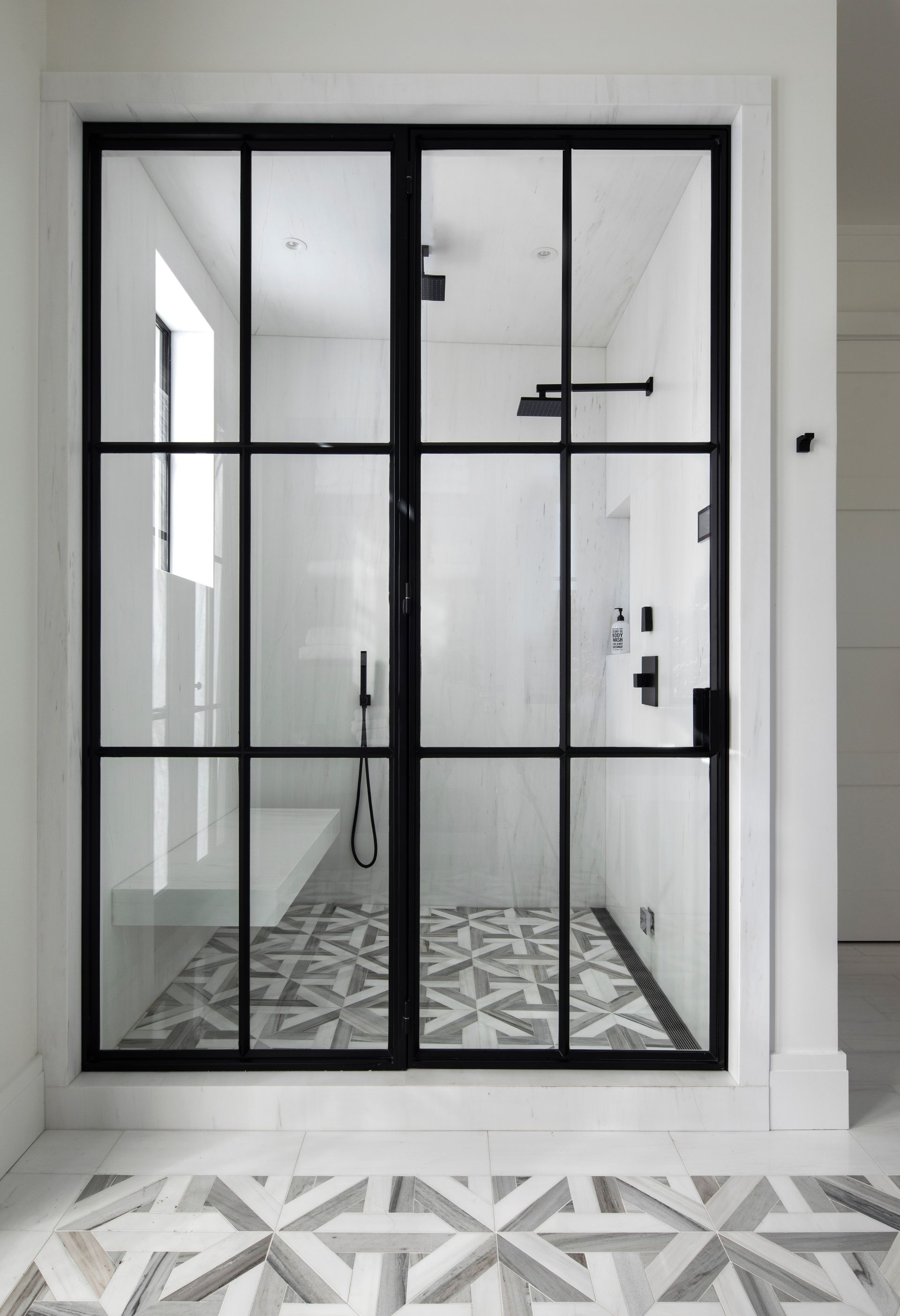 Black framed glass shower door remodeled by Nunley Custom Homes in Greenville, SC.