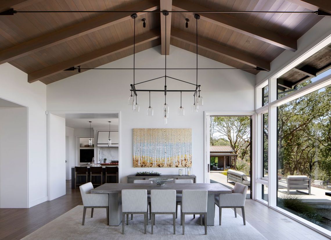 Modern dining room built by Nunley Custom Homes in Greenville, SC.overlooking a green outdoor area.