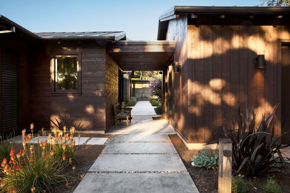 Brown-sided modern home with a concrete pathway built by Nunley Custom Homes in Greenville, SC.