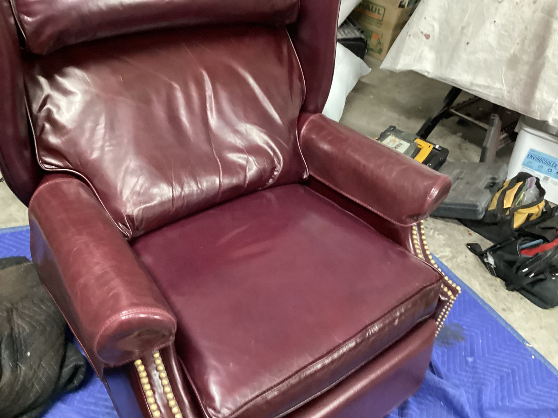 A burgundy leather recliner is sitting on a blue table.