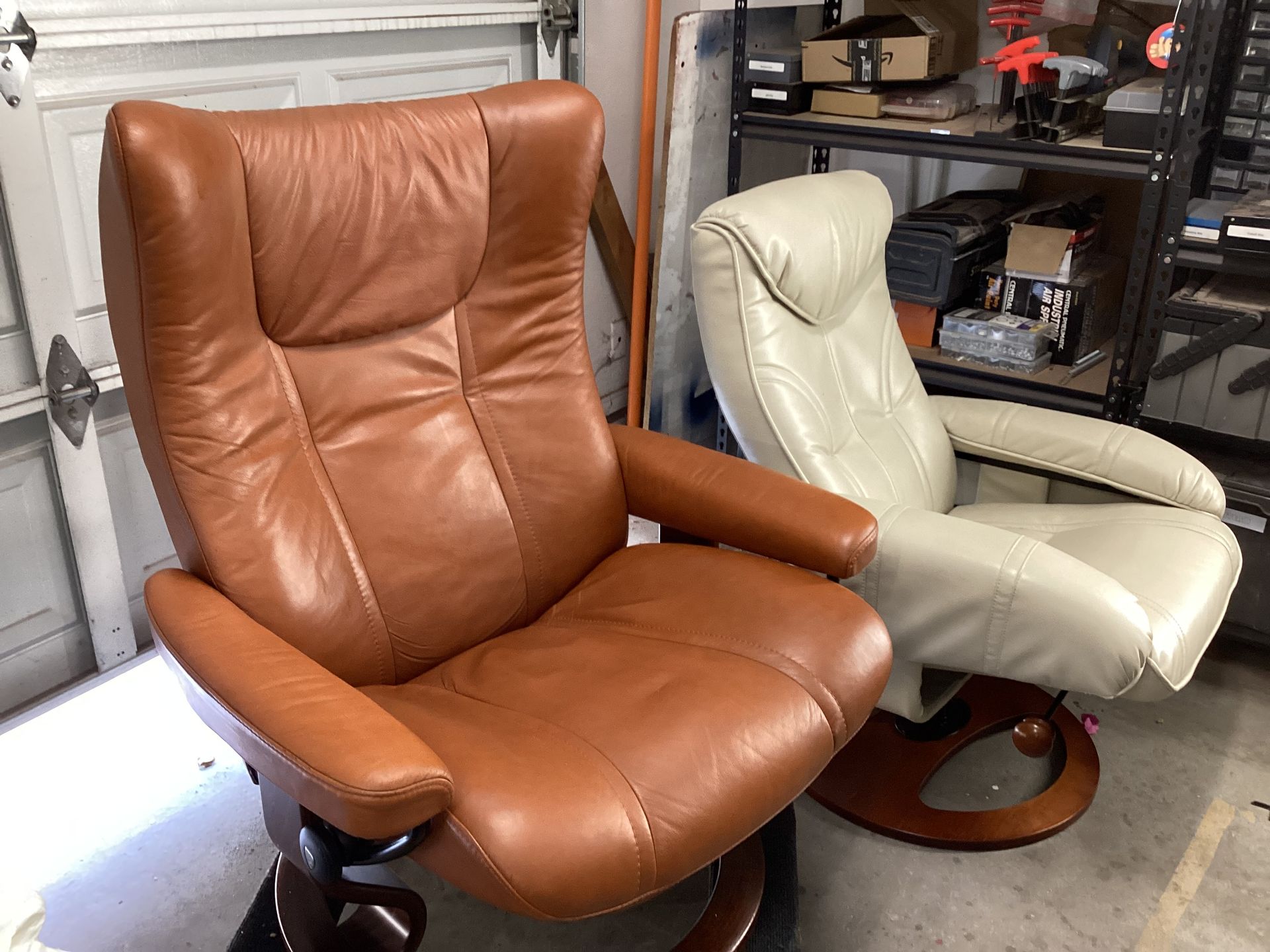 Two leather chairs are sitting next to each other in a garage.