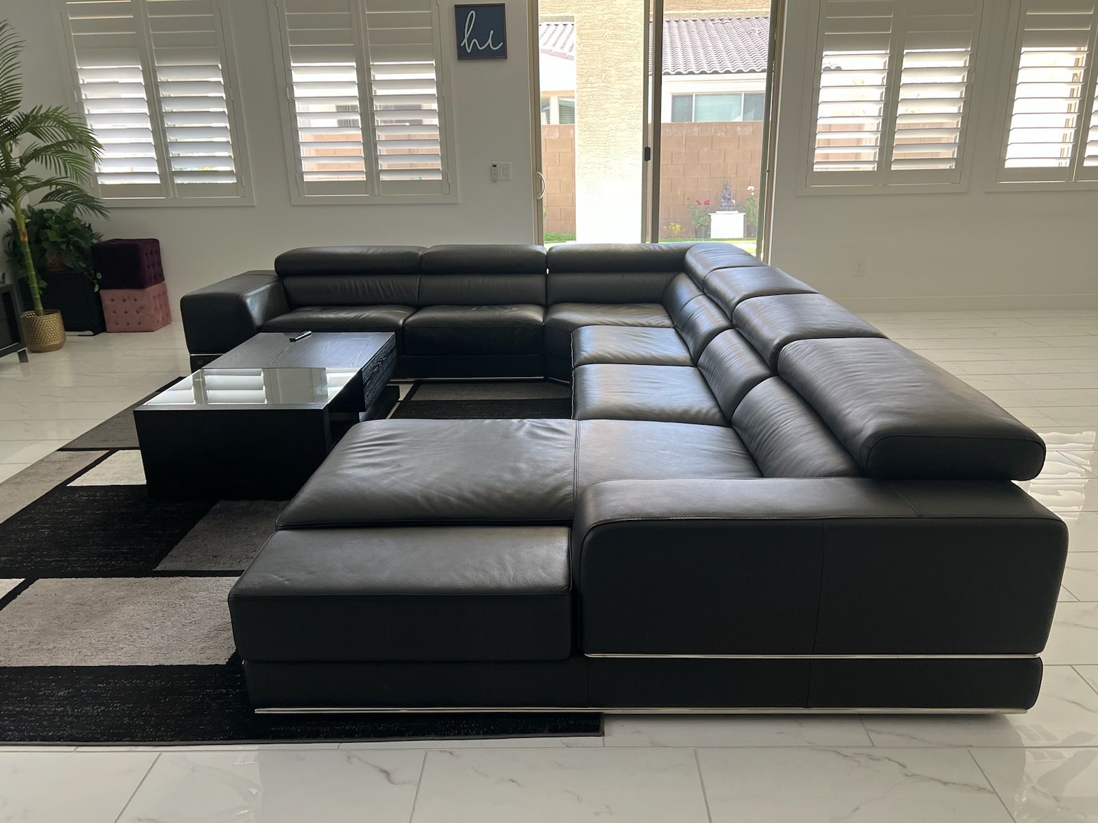 A large sectional couch is sitting in a living room next to a coffee table.