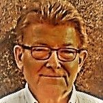 A close up of a man wearing glasses and a white shirt.