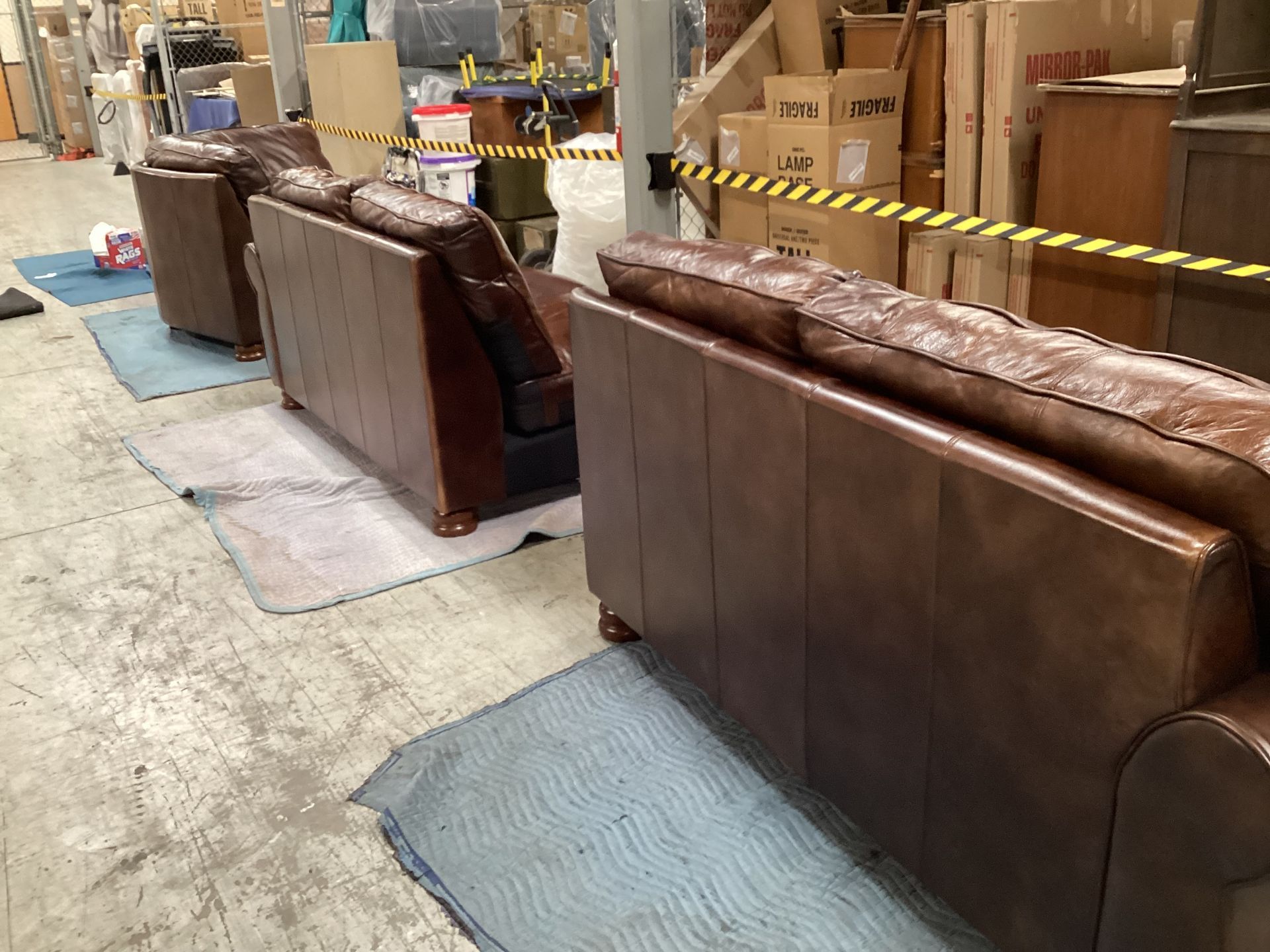 A row of brown leather couches in a warehouse