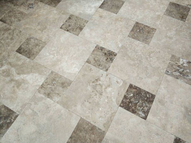 Checkerboard beige and brown marble tile floor with textured stone pattern, close-up view.