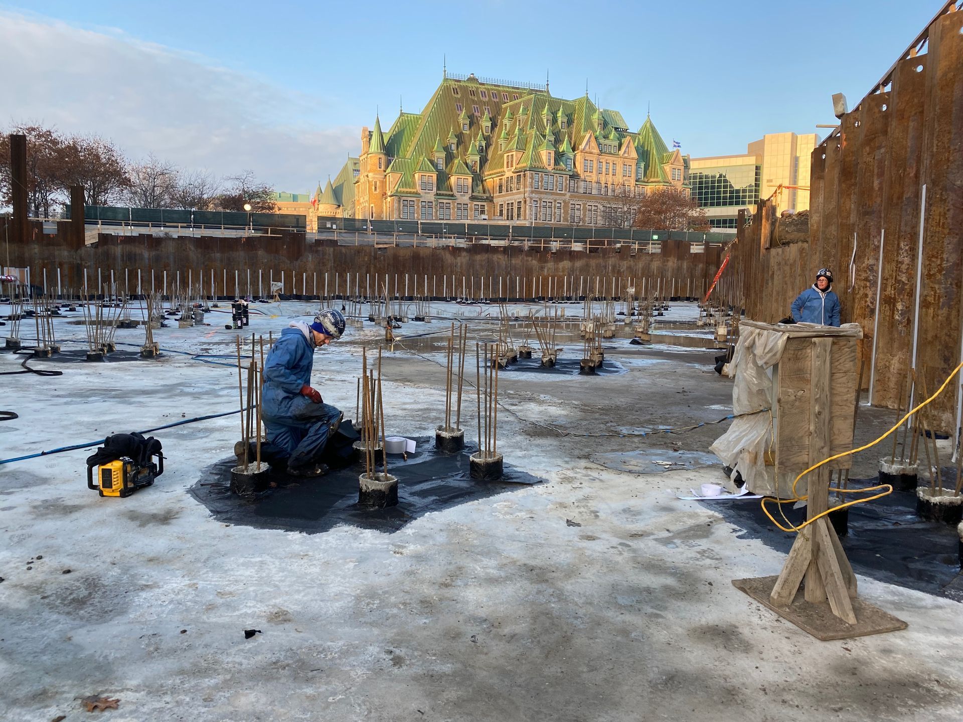 Un homme travaille sur un chantier de construction avec une montagne en arrière-plan.