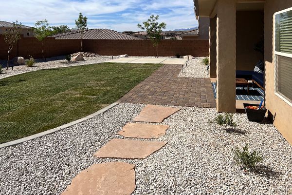 A stone walkway leads to a lush green yard