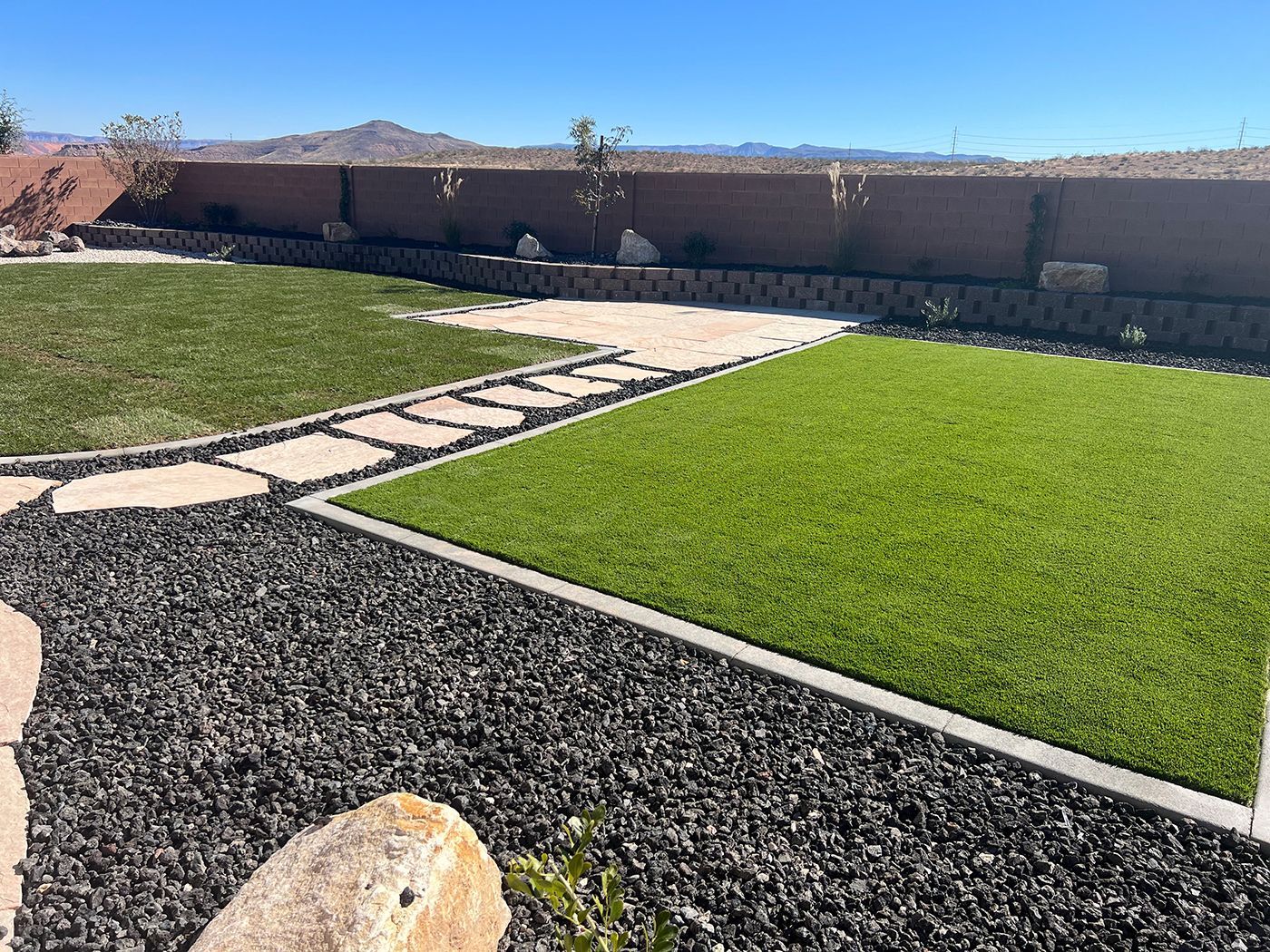 A lush green lawn with a stone walkway leading to it.